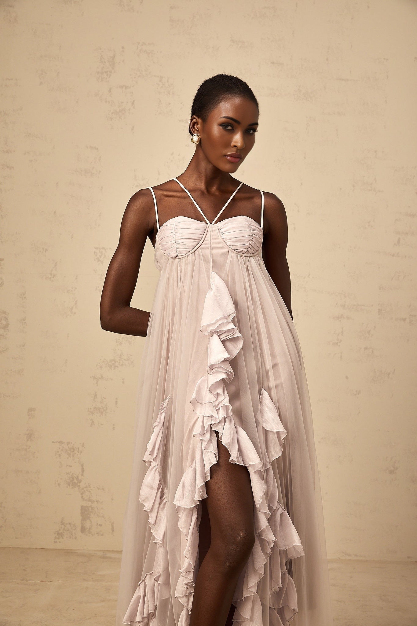 A long purple maxi dress with multiple layers of ruffled tulle fabric creating a flowing and romantic silhouette