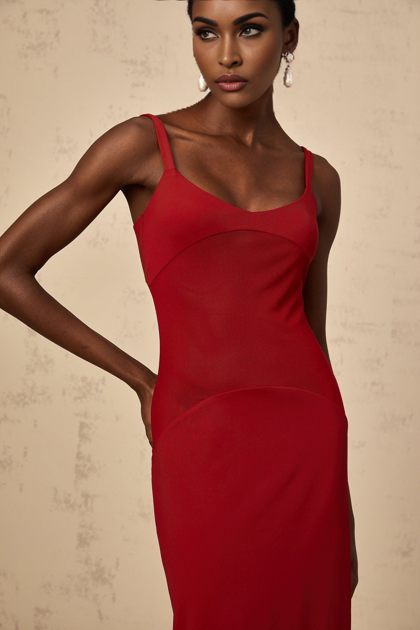 A long red dress with sheer tulle panels by Celine featuring a flowy maxi silhouette
