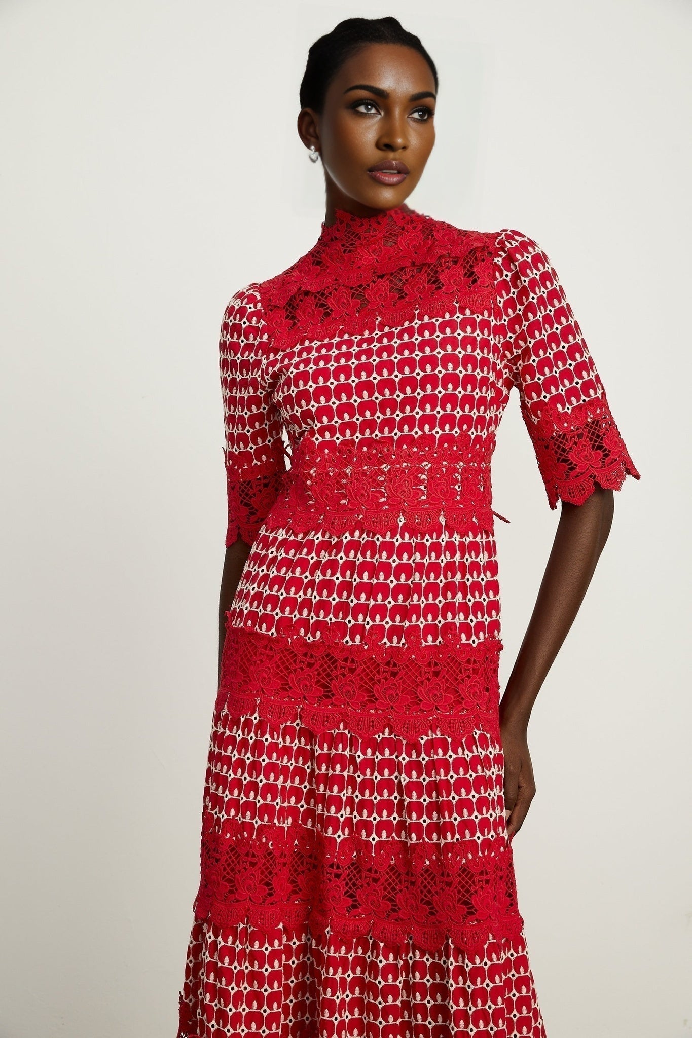 A long red maxi dress with scalloped lace panels and a feminine silhouette