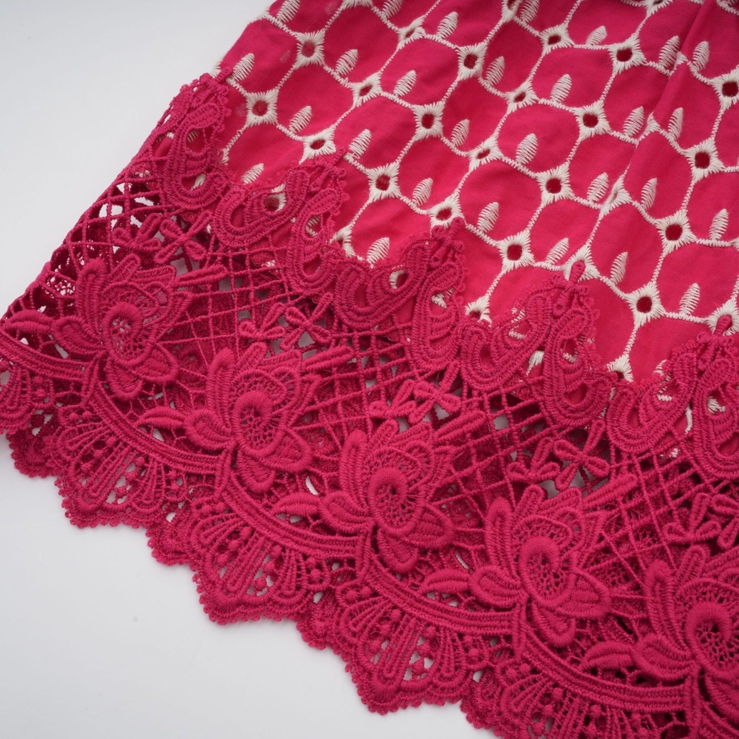 A long red maxi dress with scalloped lace panels featuring a delicate pattern throughout