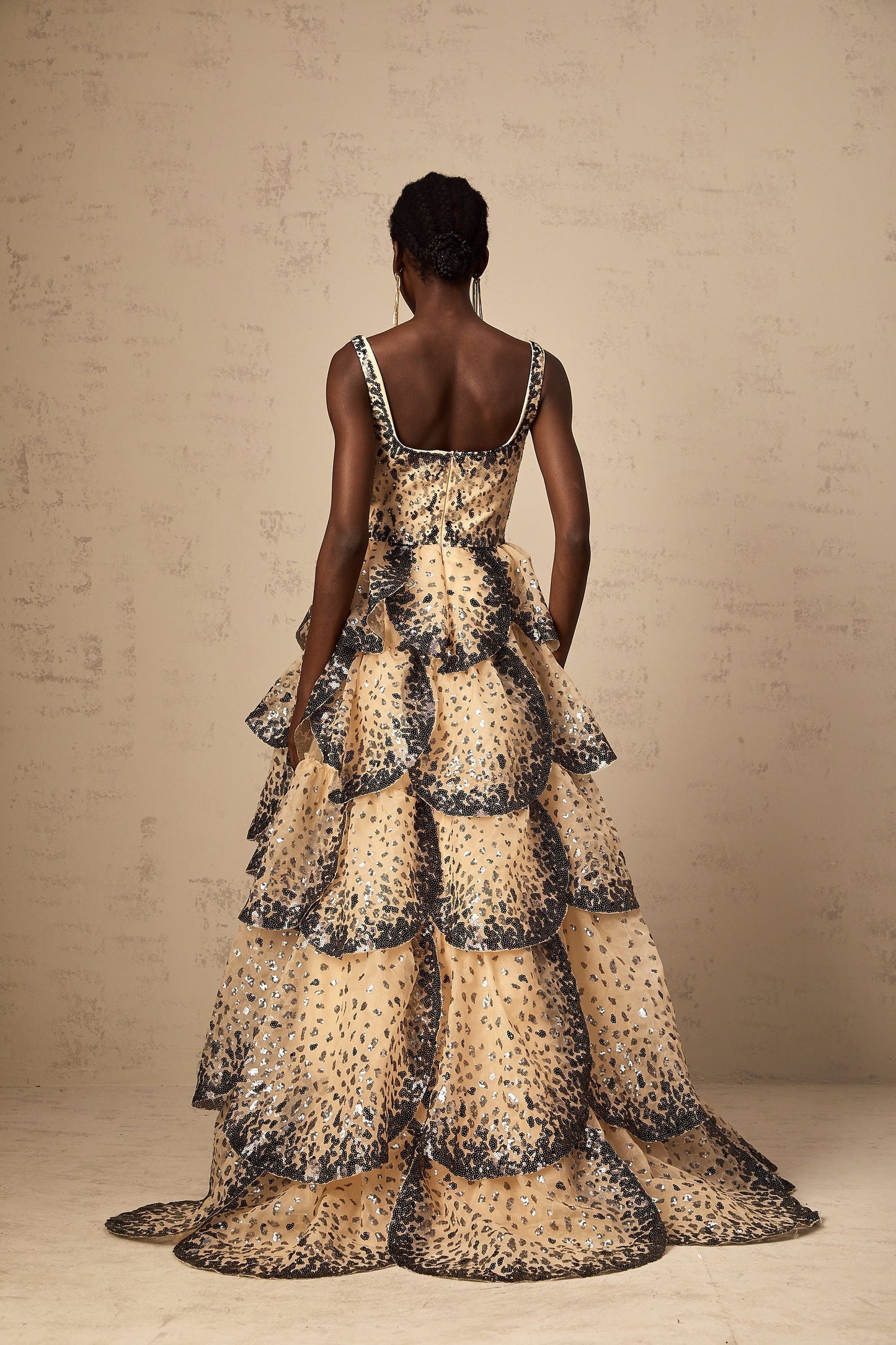 A long tiered maxi dress with sequined petal details and a flowing silhouette