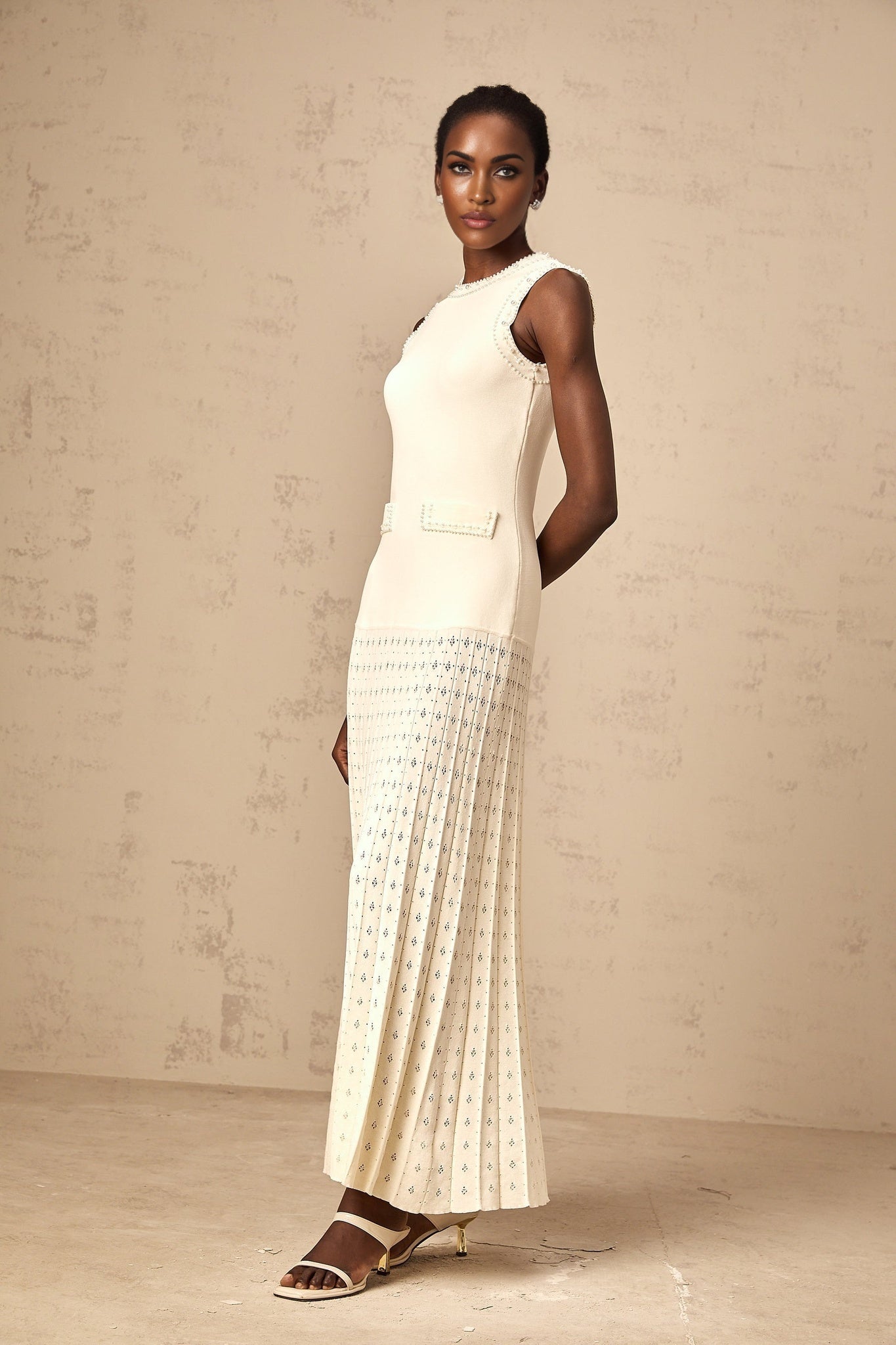 A long white knitted maxi dress with faux pearl embellishments