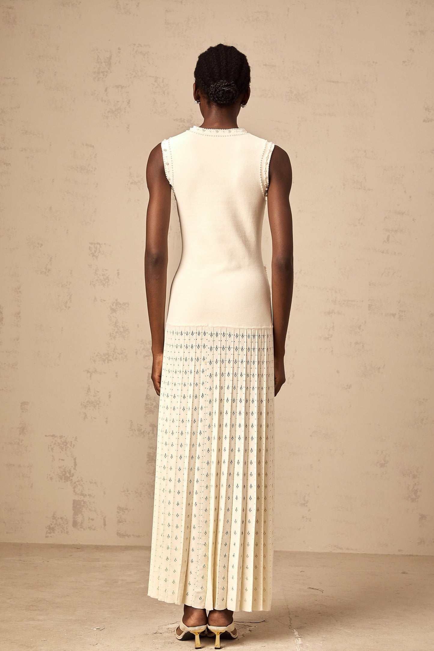 A long white knitted maxi dress with faux pearl embellishments