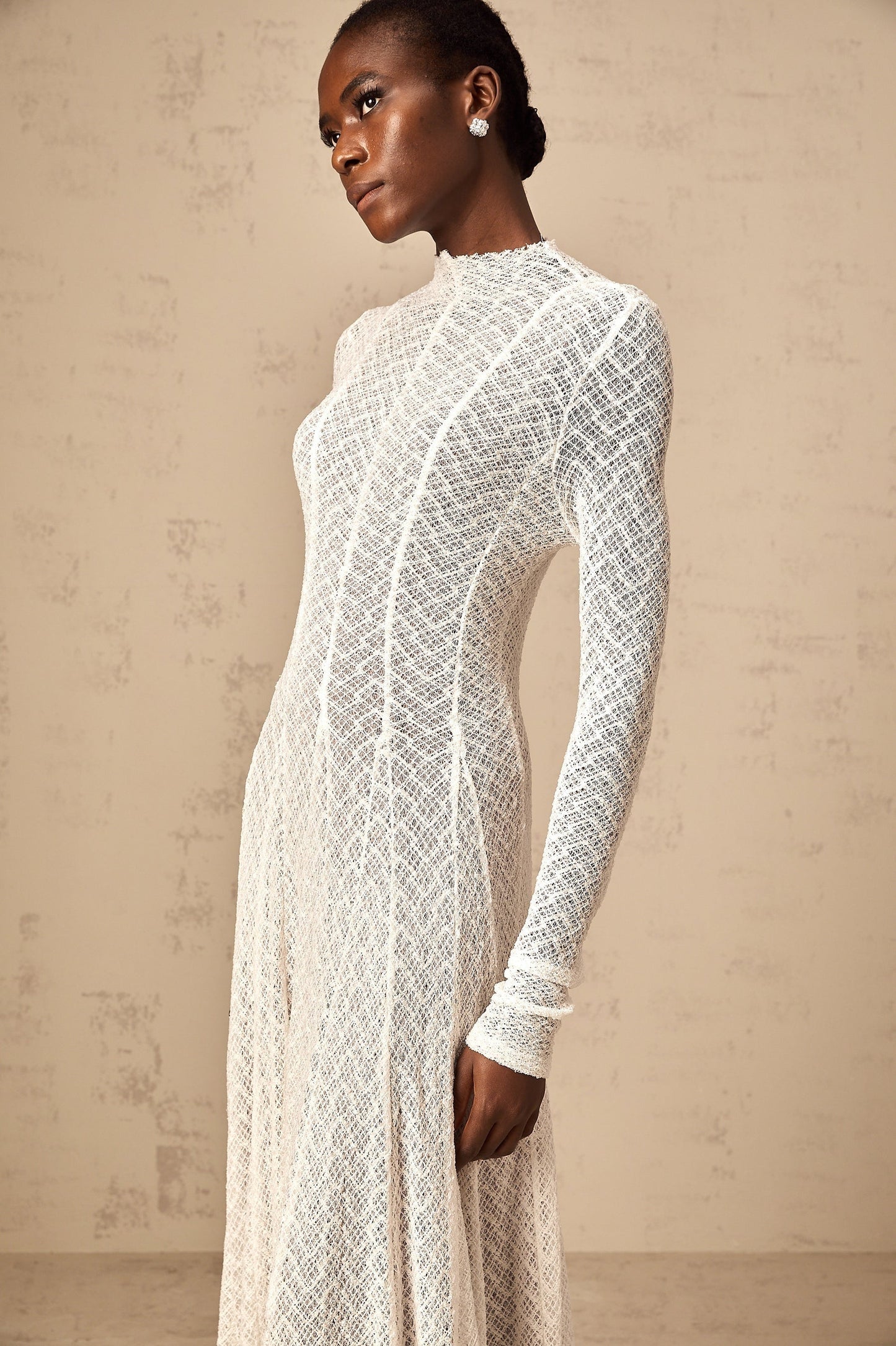 A long white lace maxi dress with a wavy pattern design called Athena