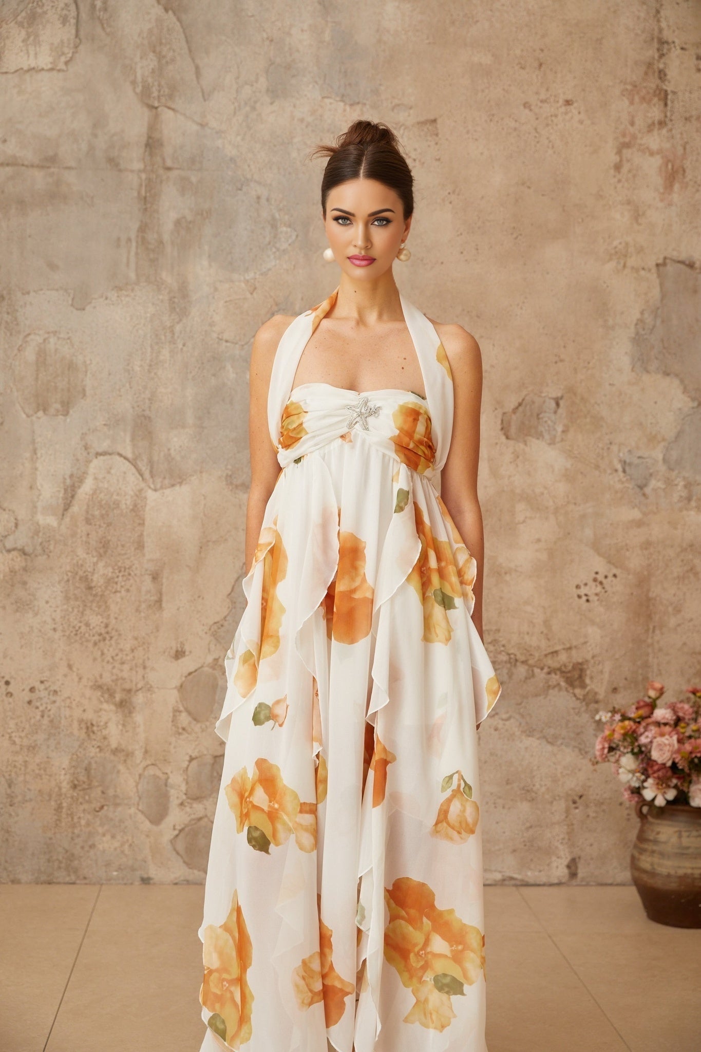 A long white maxi dress with floral print and ruffled tulle details featuring a romantic and feminine design perfect for special occasions