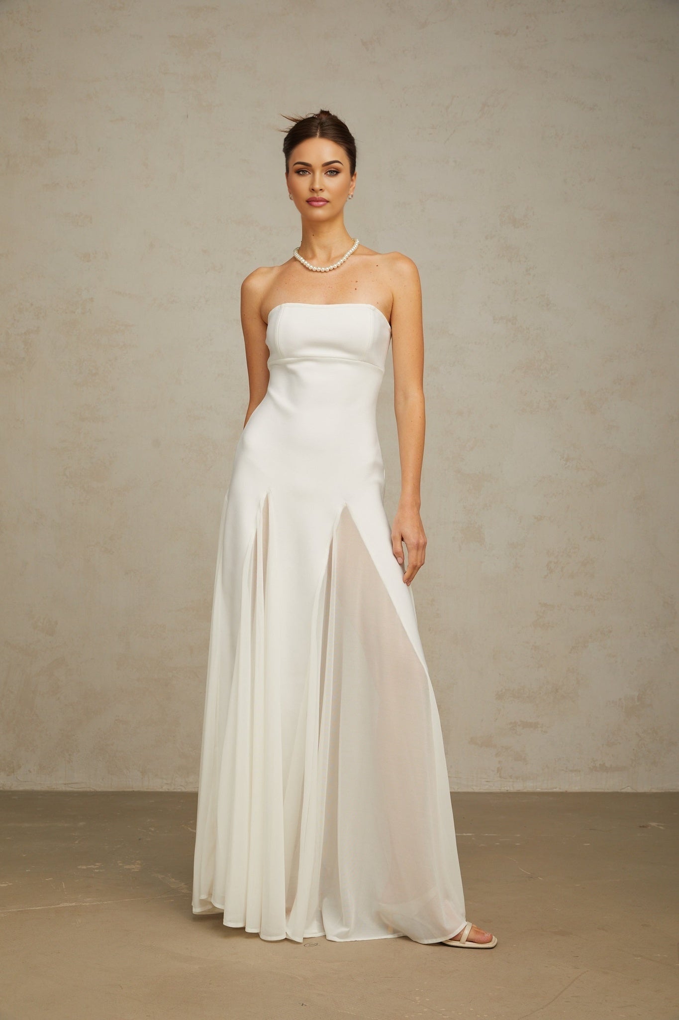 A long white maxi dress with tulle panels named Nathalie featuring a flowy silhouette and delicate design