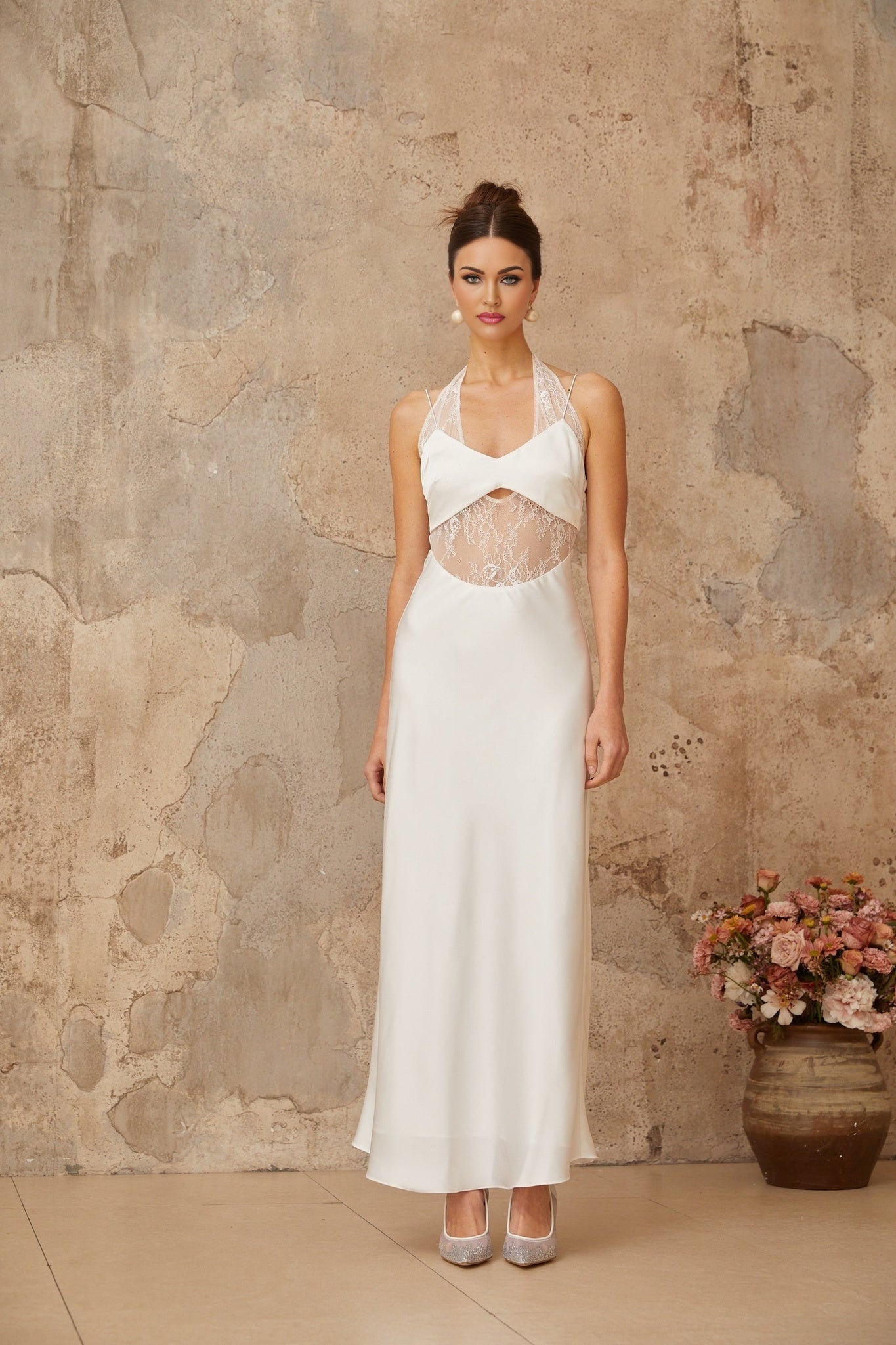 A long white satin maxi dress with lace panel details and a flowing silhouette