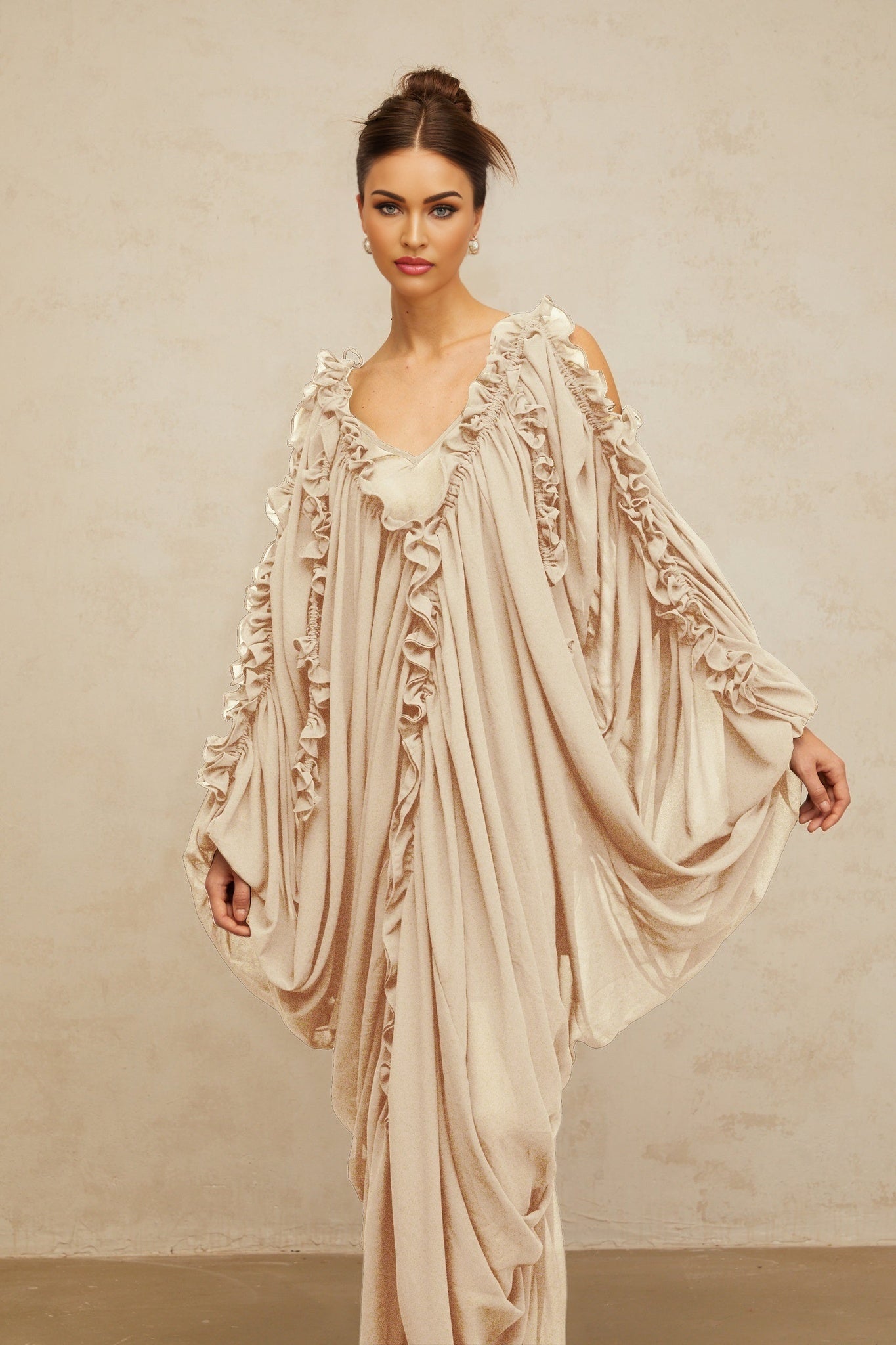 A long white tulle maxi dress with ruffled trim details and flowing layers