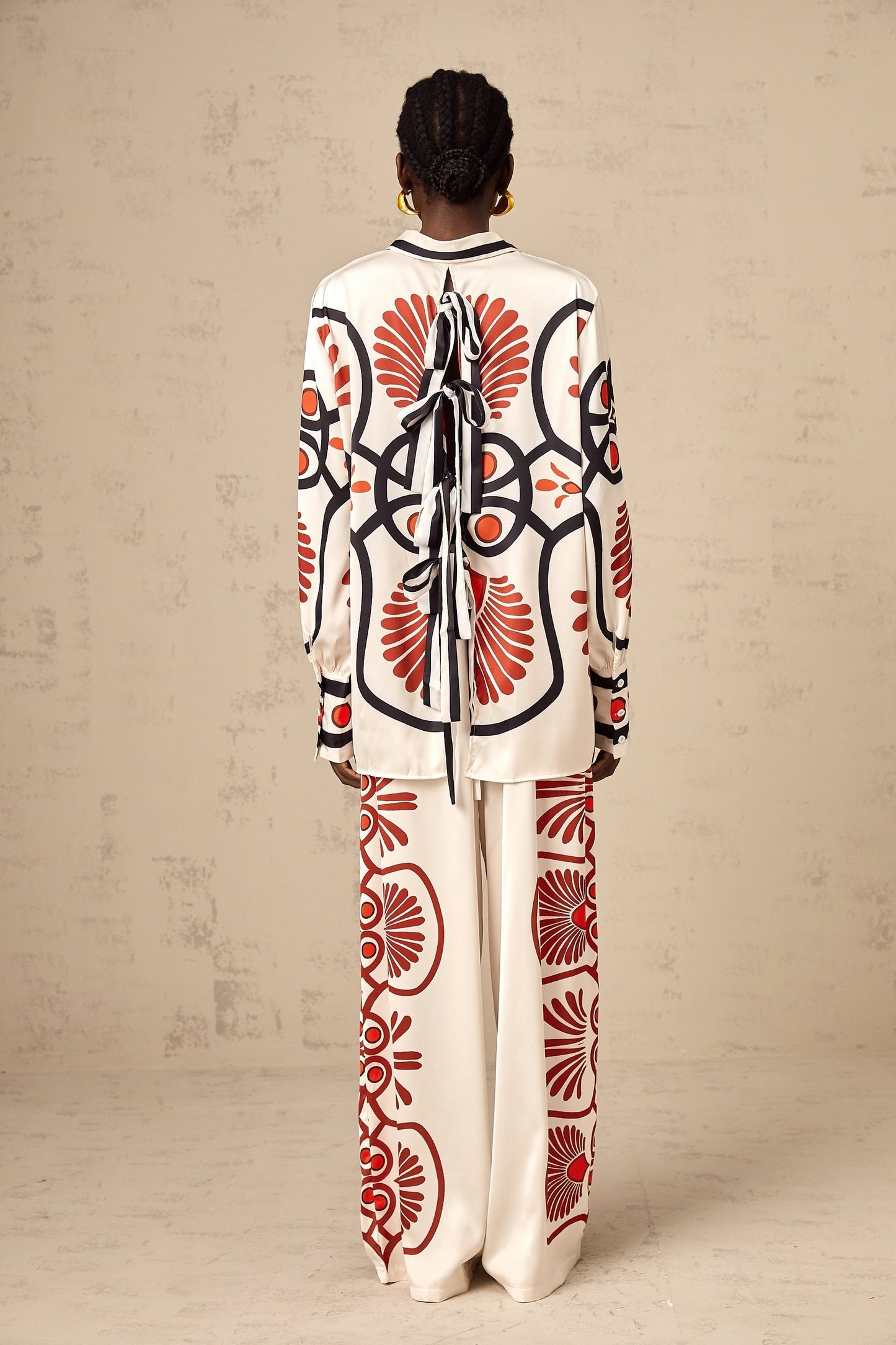 A matching set consisting of a shirt and trousers with a graphic print design called Amaranta The outfit features a coordinated pattern on both pieces