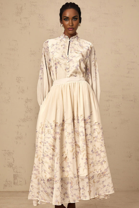 A matching set featuring a frilled shirt and skirt in a wisteria print pattern The shirt has ruffled details and the skirt is flowy Both pieces are in a light purple color with a floral design