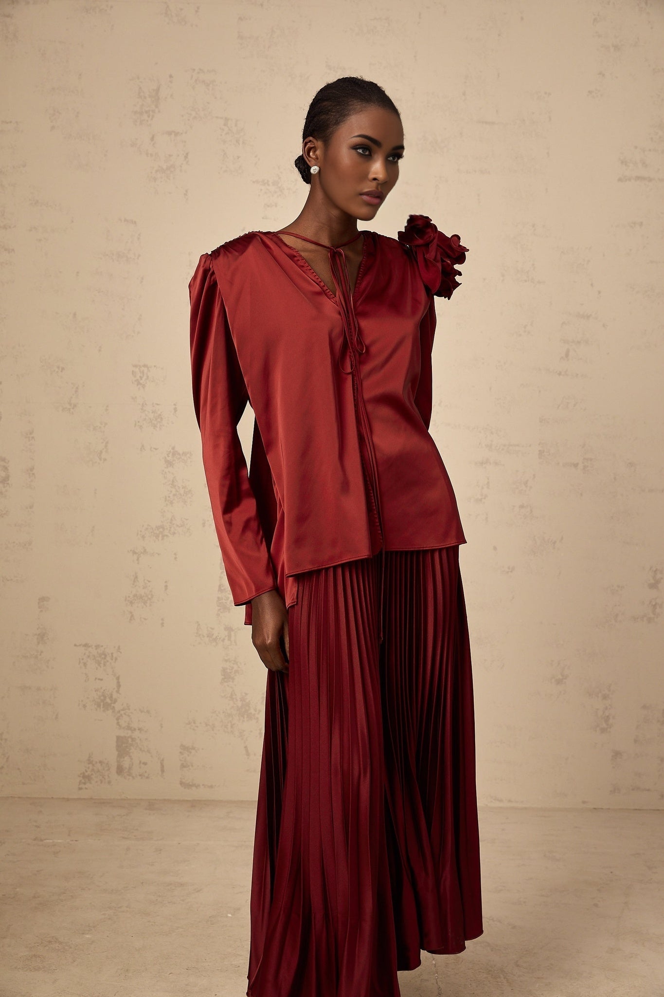 A matching set featuring a satin blouse and skirt with floral applique details in a style called Colette