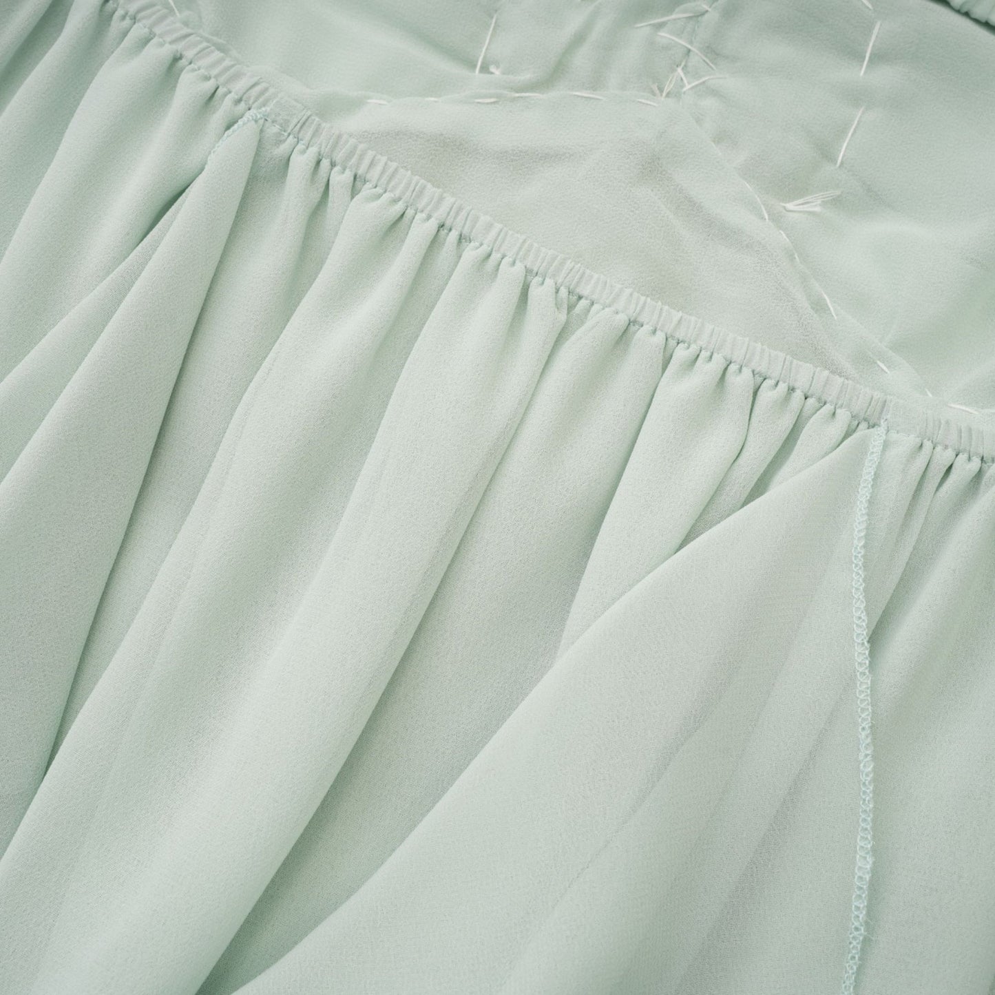 A midi dress with ruffles and embellishments called Salilah featuring a feminine silhouette and decorative details