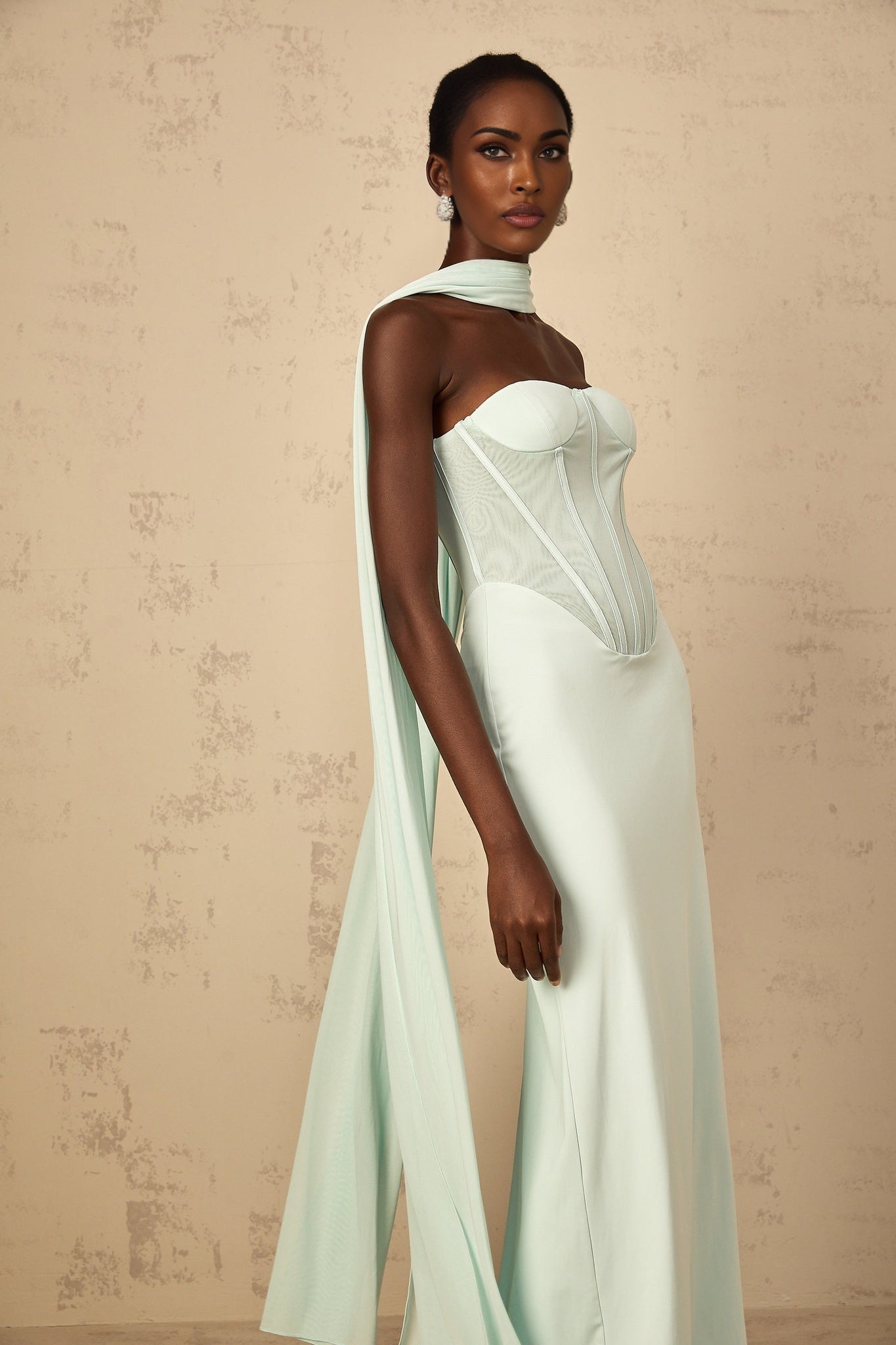 A mint green maxi dress with a corset bodice and tulle panel skirt featuring a long flowing silhouette and delicate feminine design