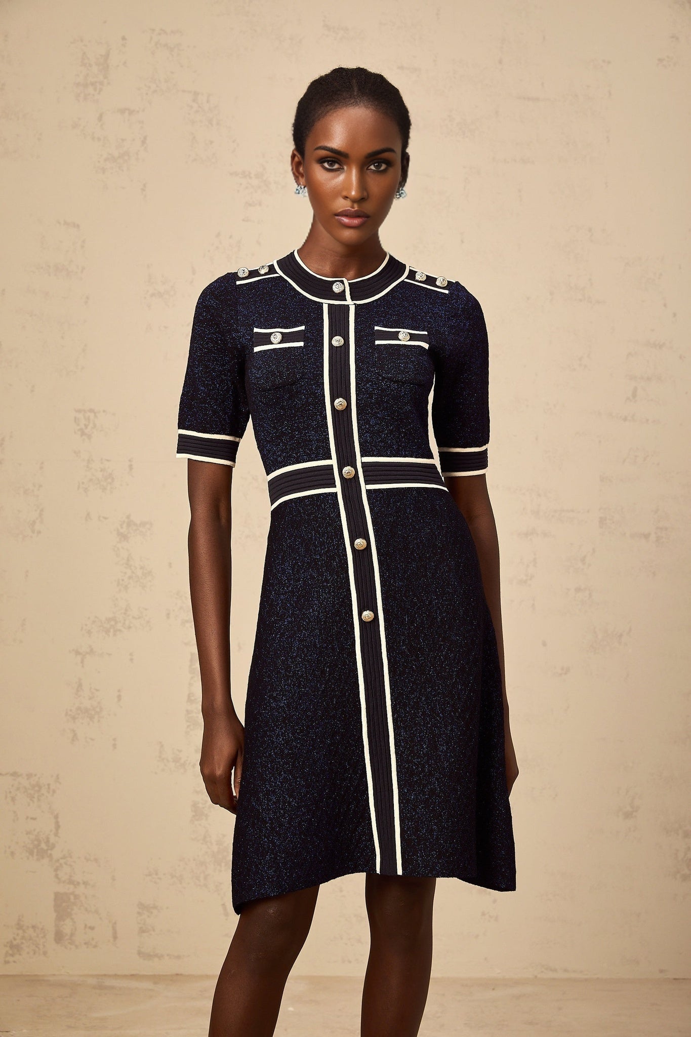A navyblue mini dress with glitter knit fabric featuring a formfitting silhouette and short length named Paulette