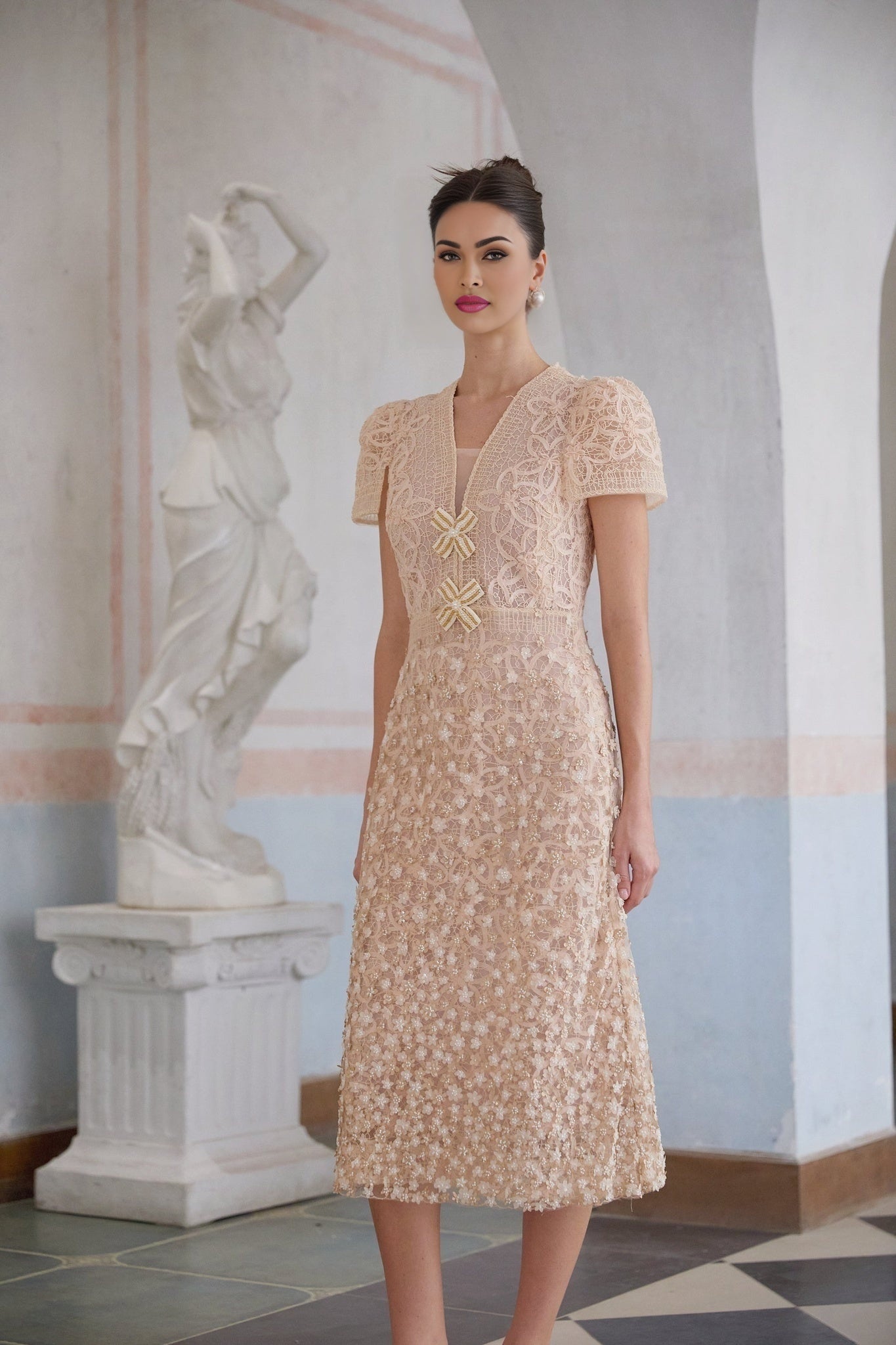 A neutral colored midi dress with a crochet design and faux flower embellishments