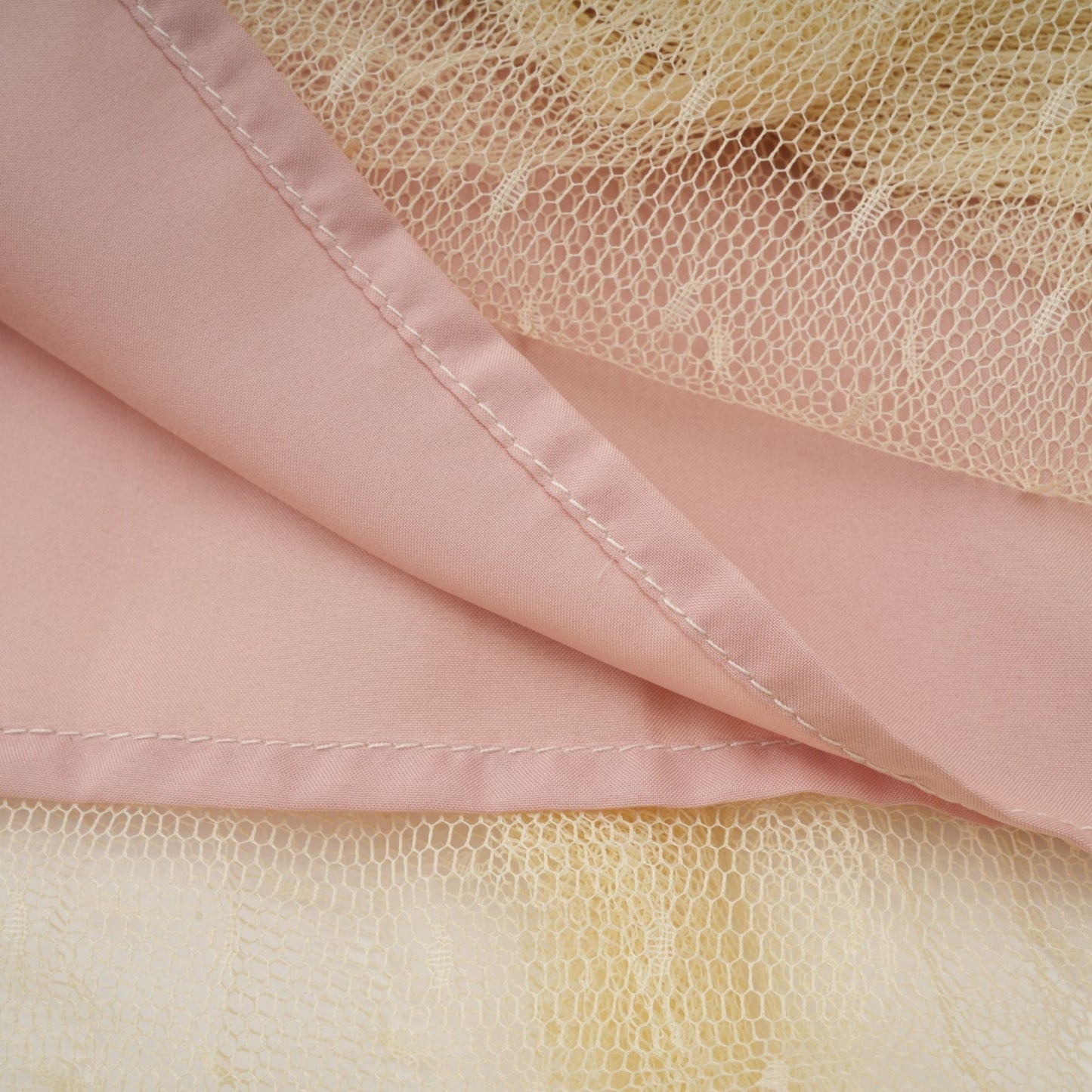 A neutral colored midi dress with floral lace paneling and tulle fabric featuring a delicate and feminine design