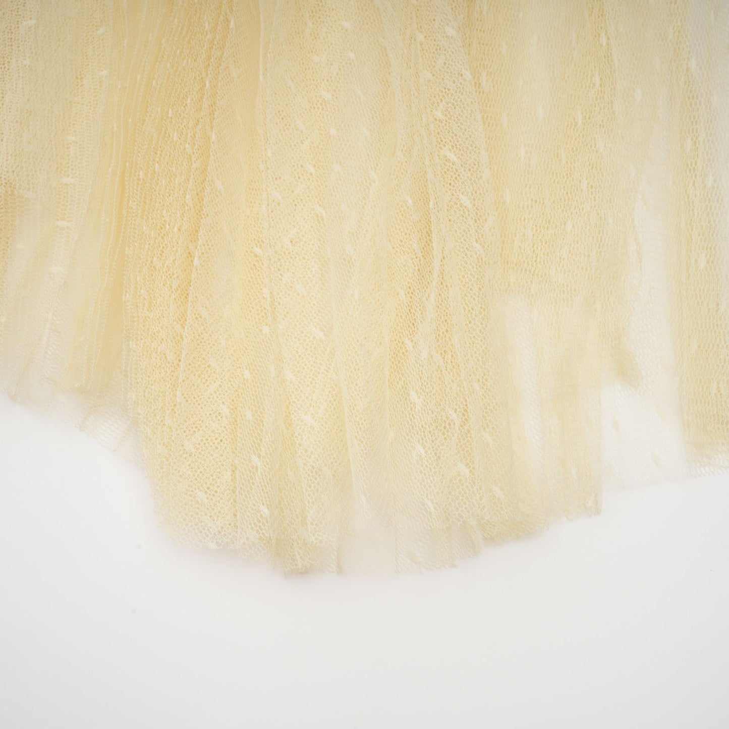 A neutral colored midi dress with floral lace panels and tulle details named Celeste