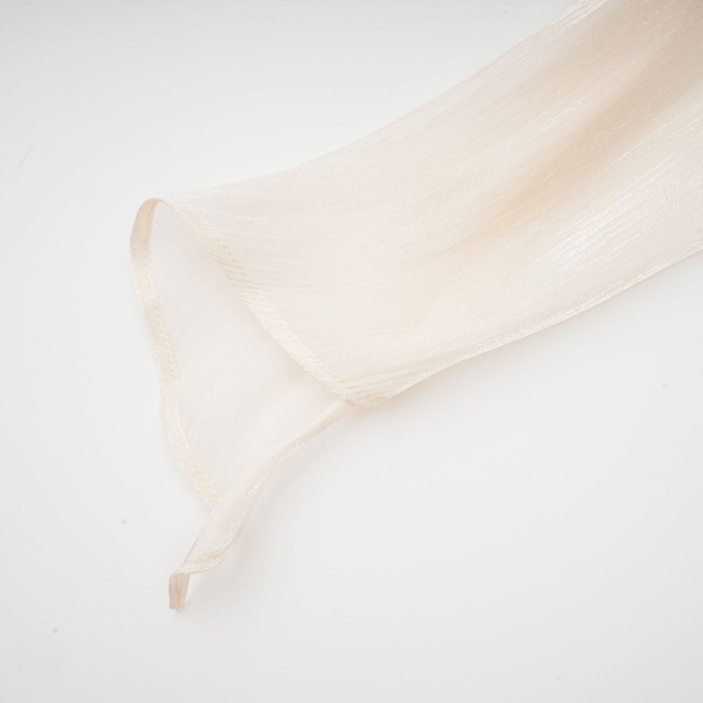 A neutral colored mini dress with full pleats and ruffles named Eugenie featuring a short hemline and feminine design