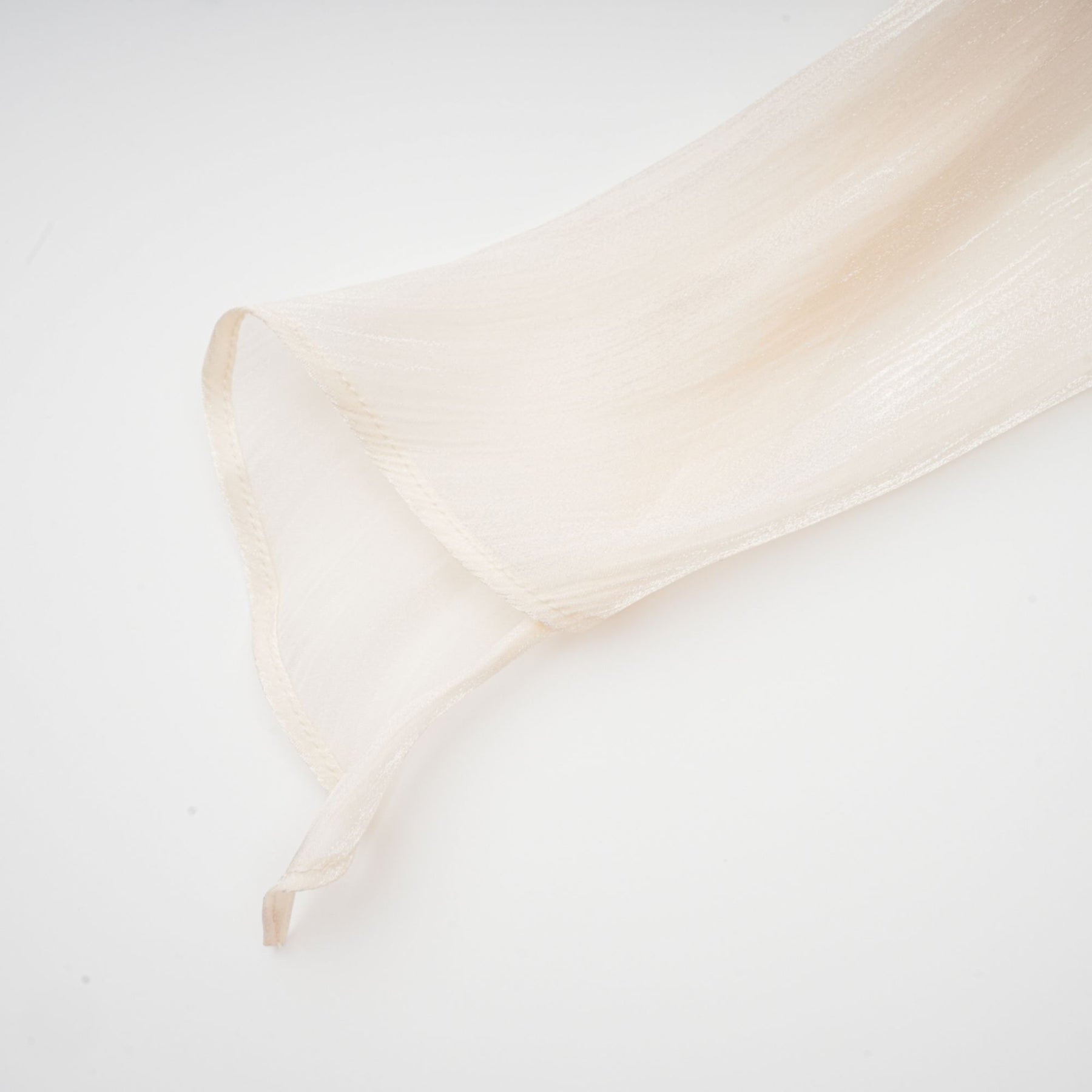 A neutral colored mini dress with full pleats and ruffles named Eugenie featuring a short hemline and feminine design