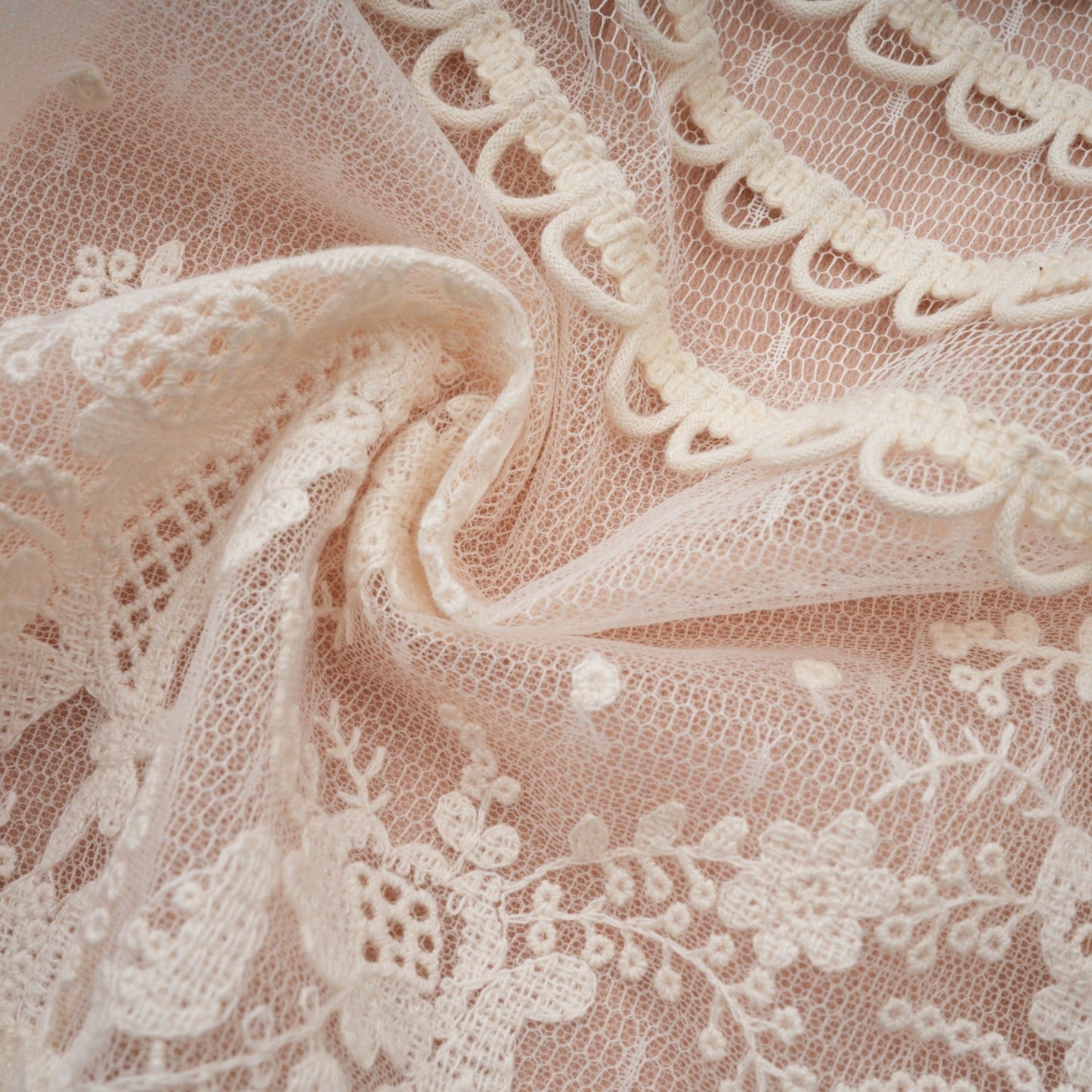 A neutralcolored midi dress with floral embroidery and lace detailing featuring a delicate fleur pattern