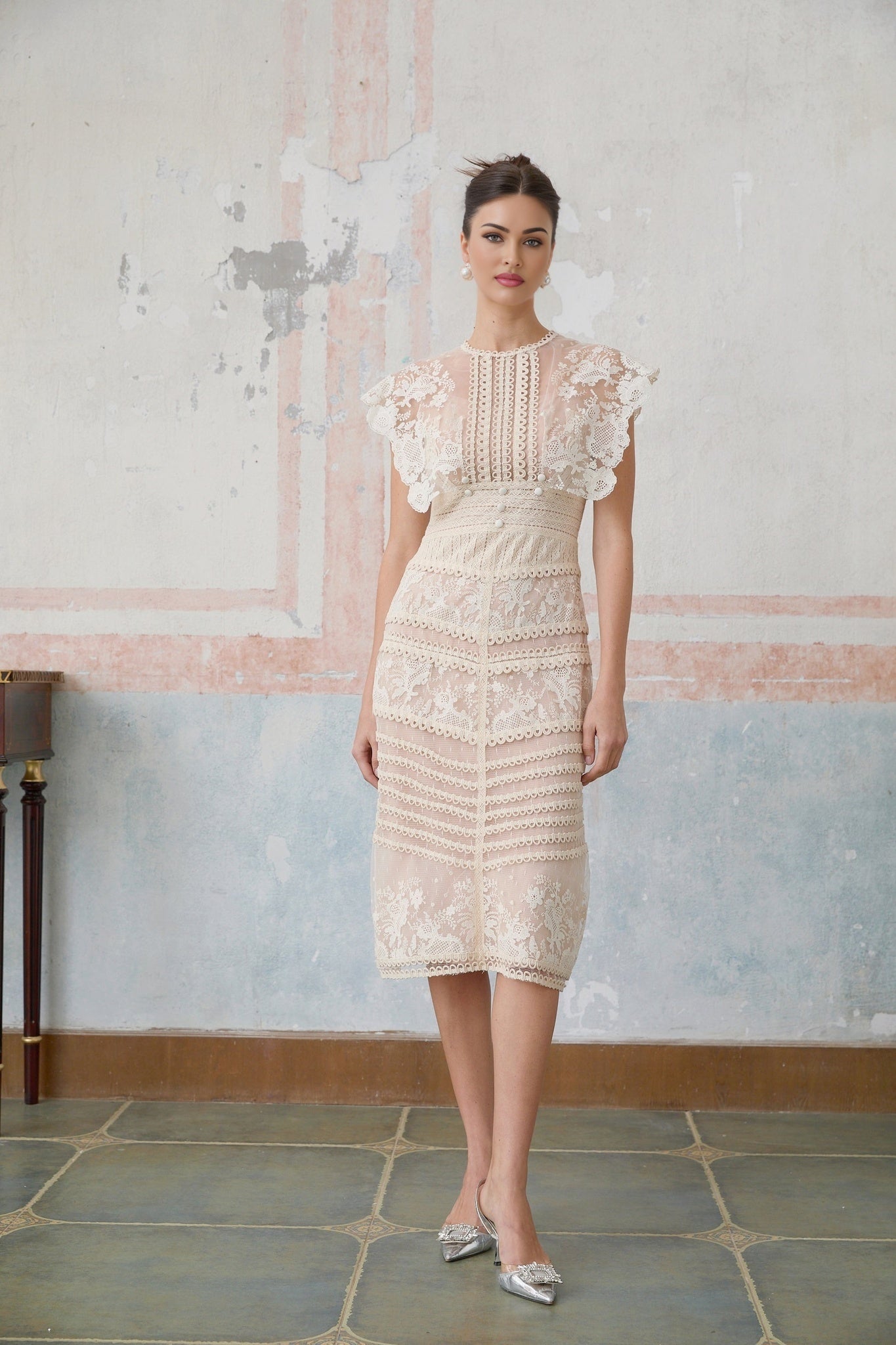 A neutralcolored midi dress with floral embroidery and lace detailing featuring delicate fleur patterns throughout the design