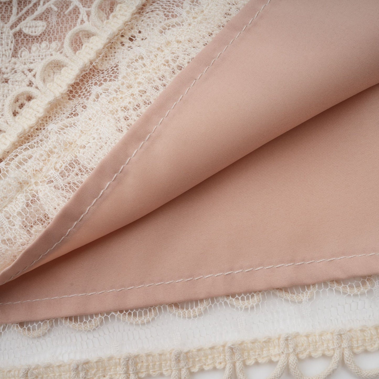 A neutralcolored midi dress with floral embroidery and lace details featuring a delicate fleur pattern