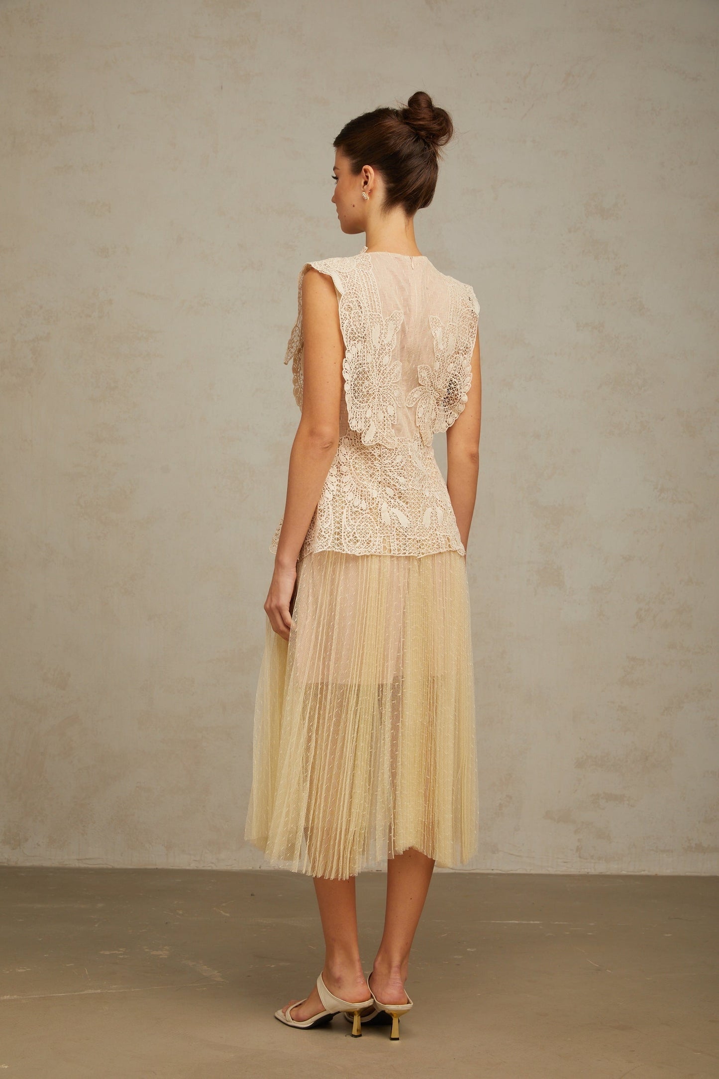 A neutraltoned midi dress featuring floral lace panelling and tulle fabric with a delicate Celeste design