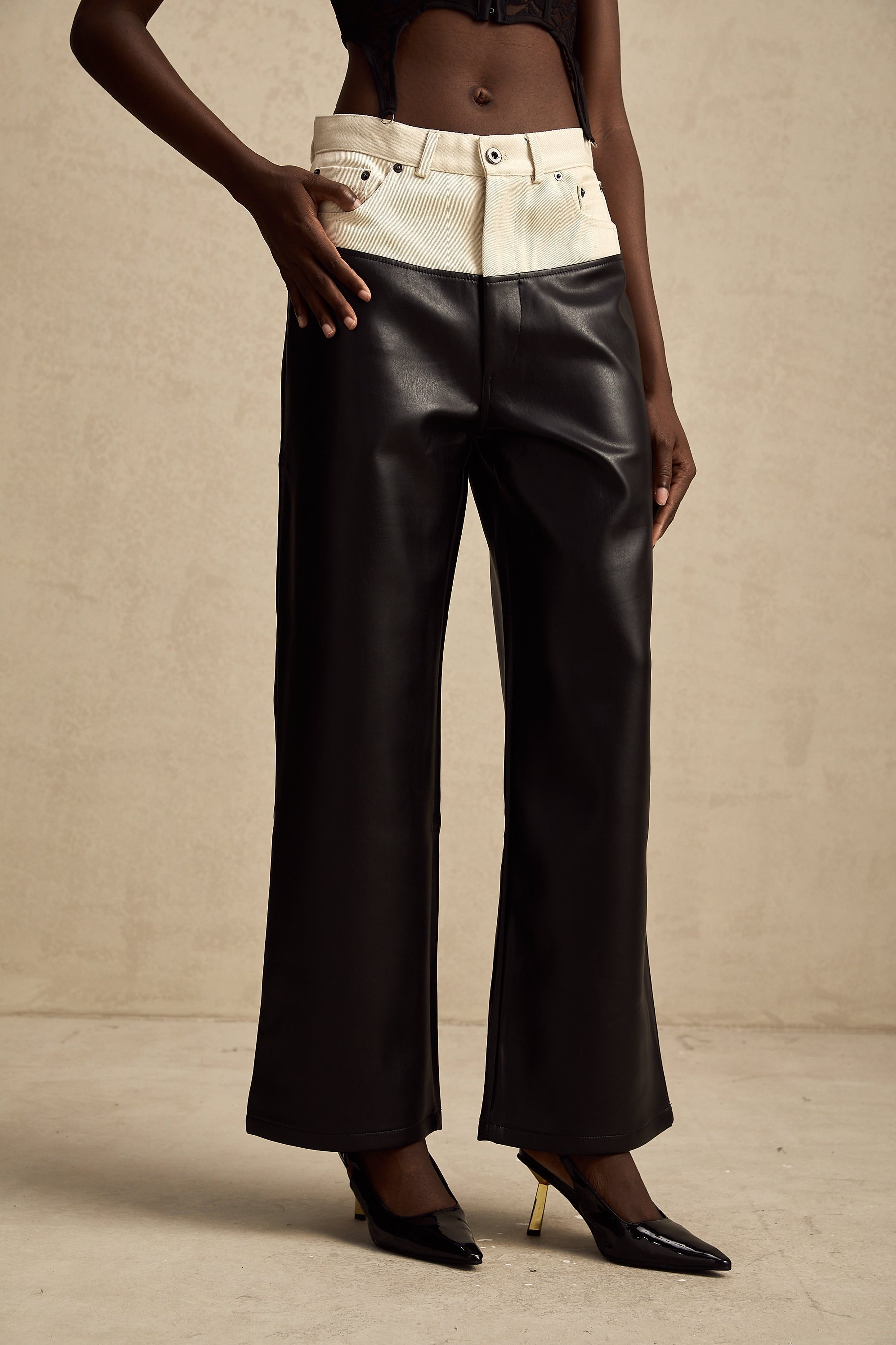 A pair of leather trousers featuring contrasting colors with the name Clotilde