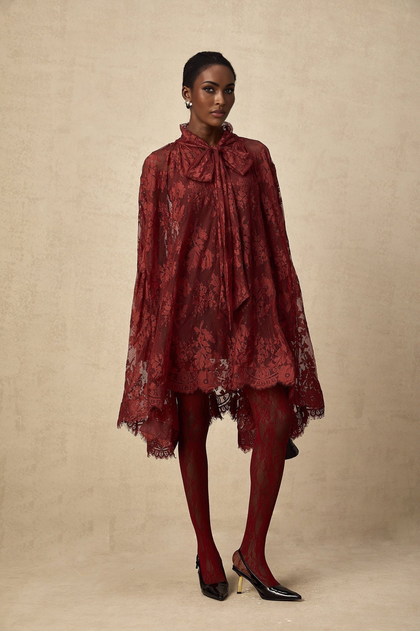 A pair of red tights with floral lace cutout patterns visible on the legs