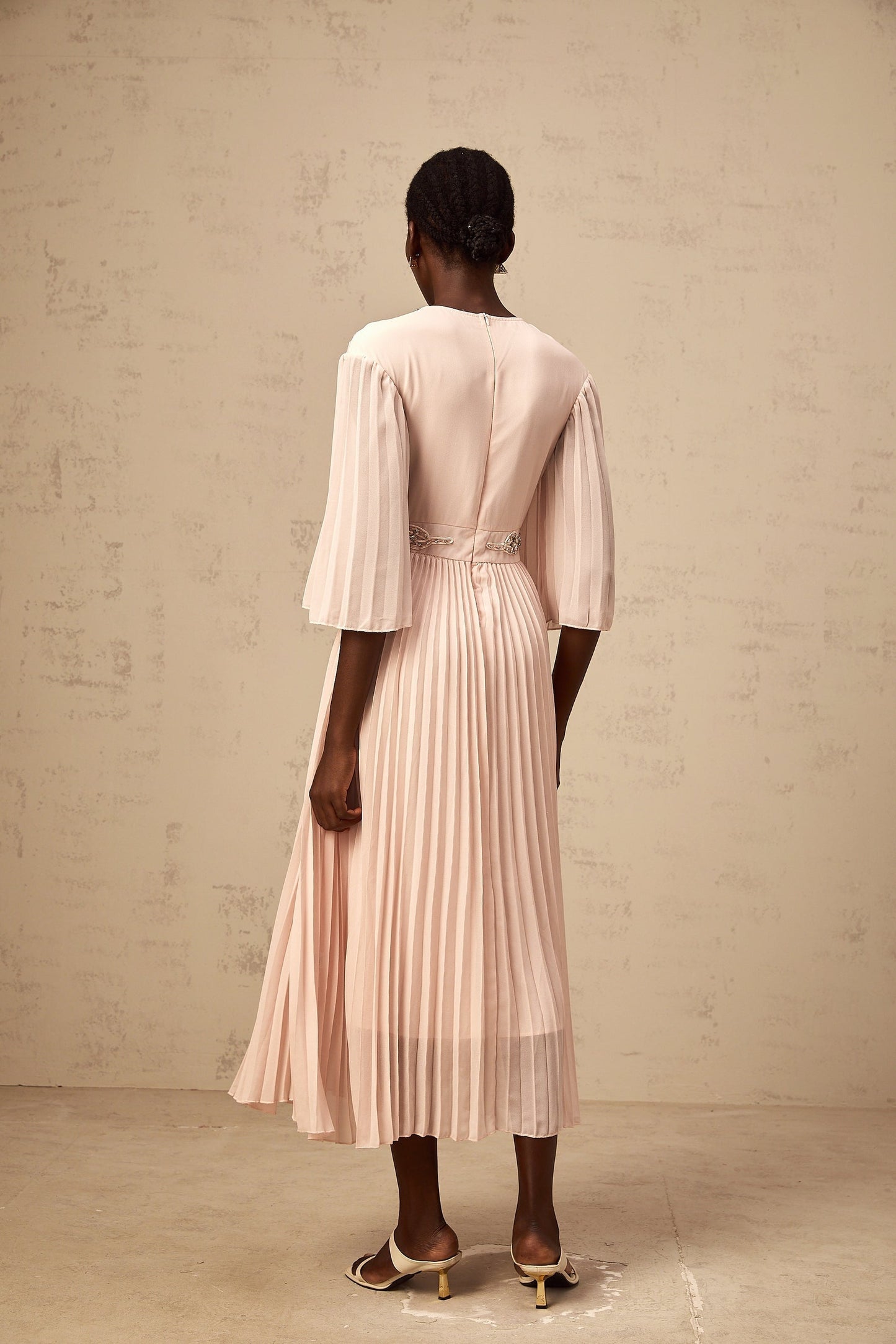 A pink crystal embellished midi dress with full pleats and a flowy silhouette named Thea