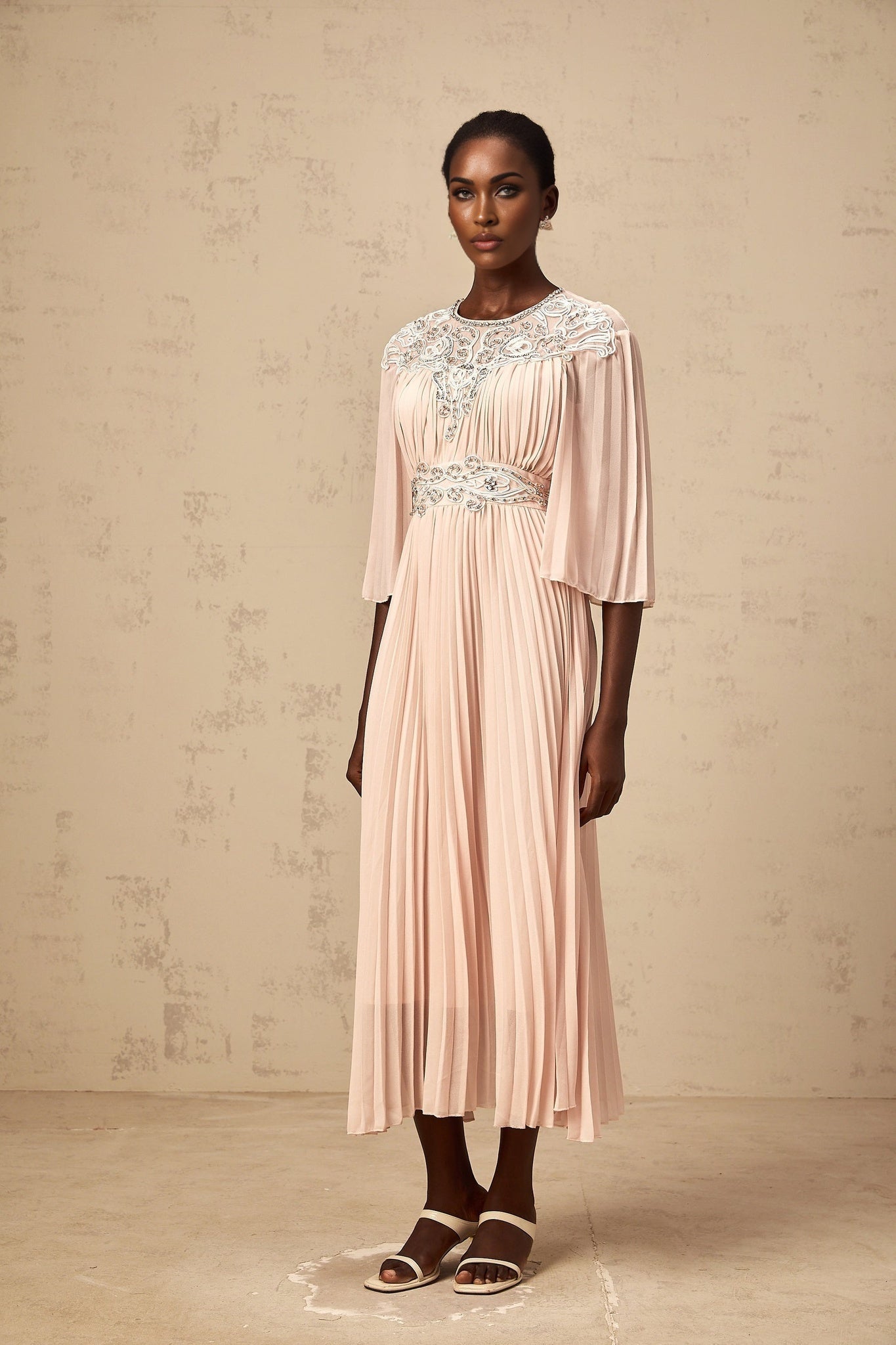 A pink crystalembellished midi dress with full pleats and a feminine silhouette named Thea