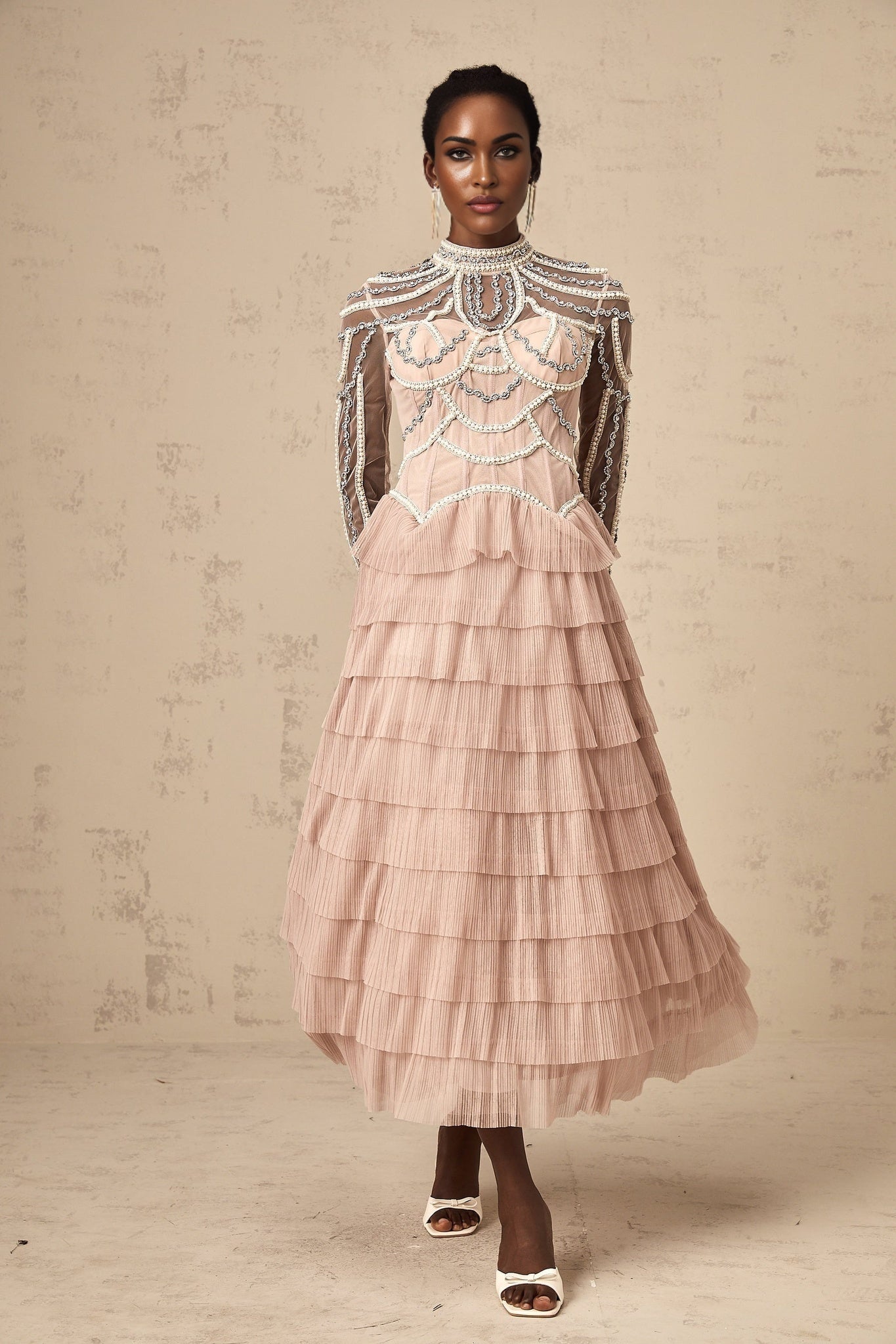 A pink gown with beaded details and tiered semisheer layers