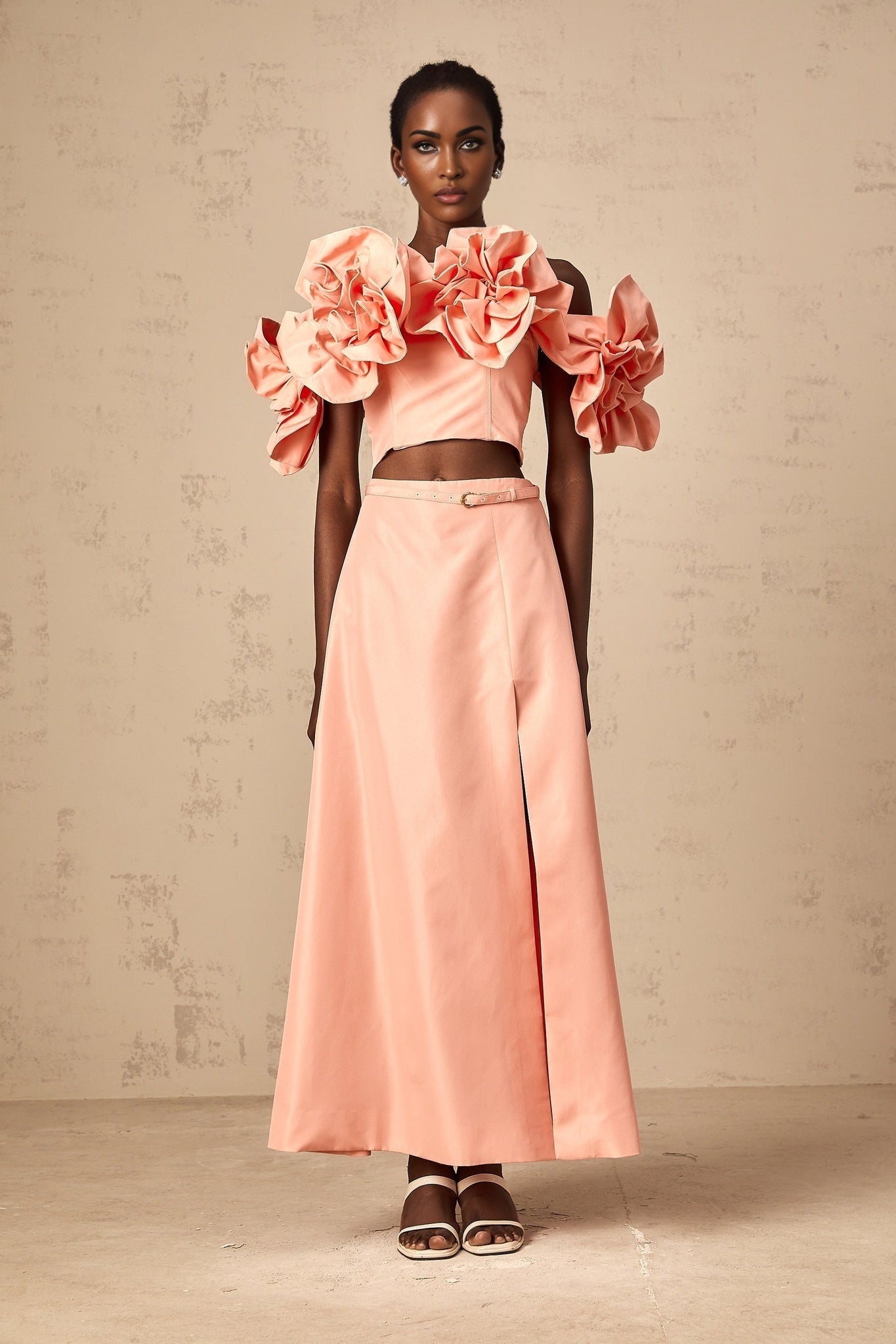 A pink matching set featuring a top and skirt with floral applique details on both pieces