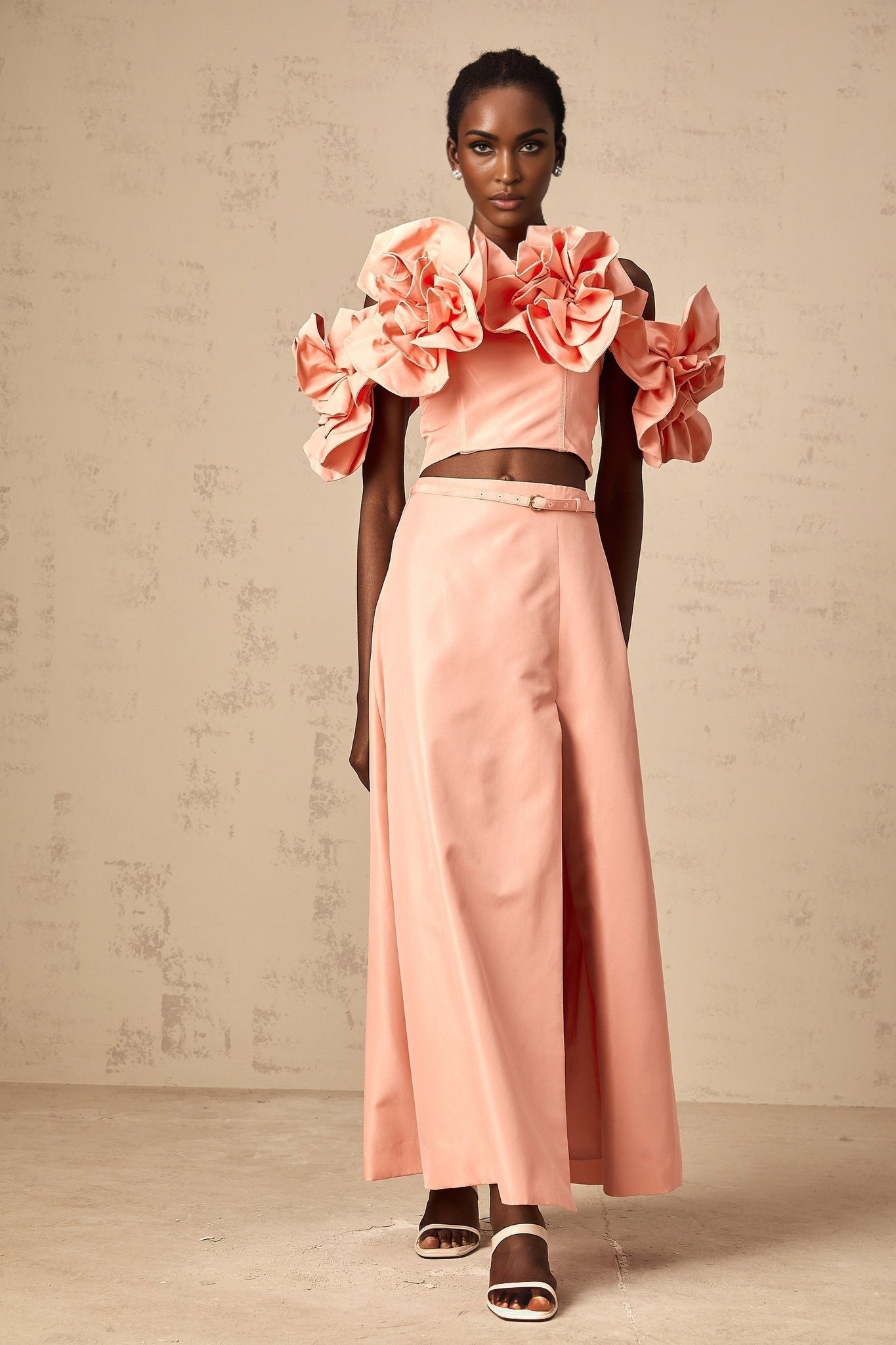 A pink matching set featuring a top and skirt with floral applique details