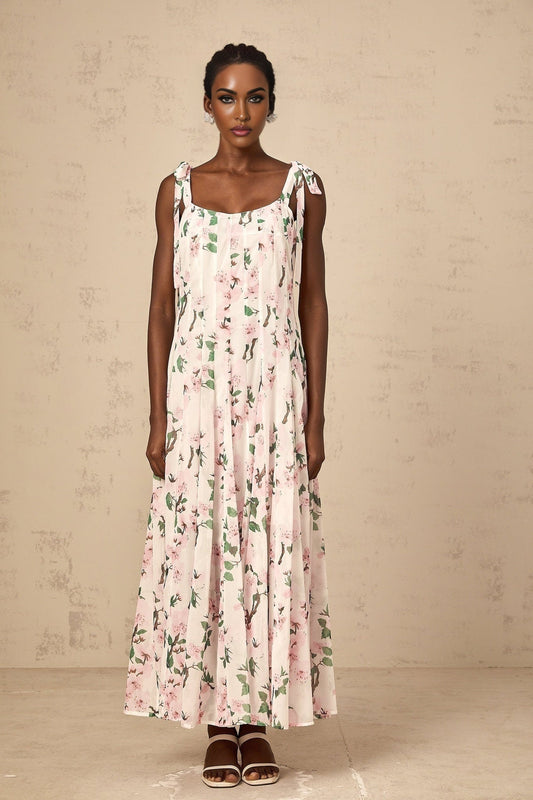A pink maxi dress with a floral print pattern and tied straps