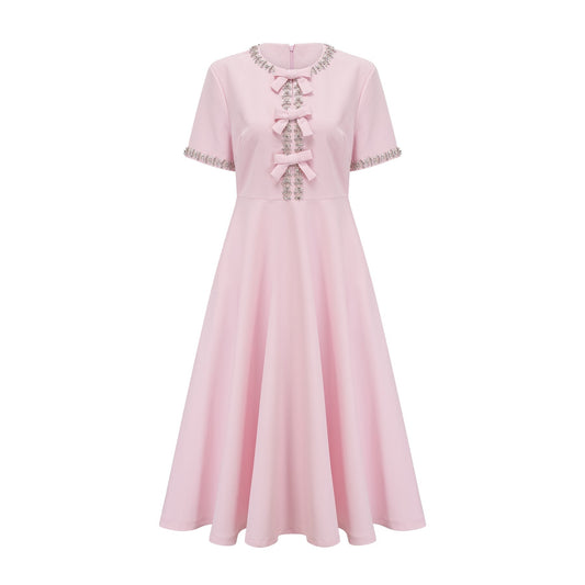 A pink midi dress with a large bow detail adorned with crystal accents named Cassiopeia