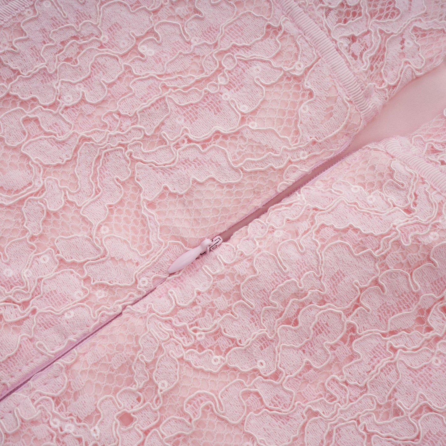A pink midi dress with floral embroidery and lace details featuring embellishments and a feminine silhouette