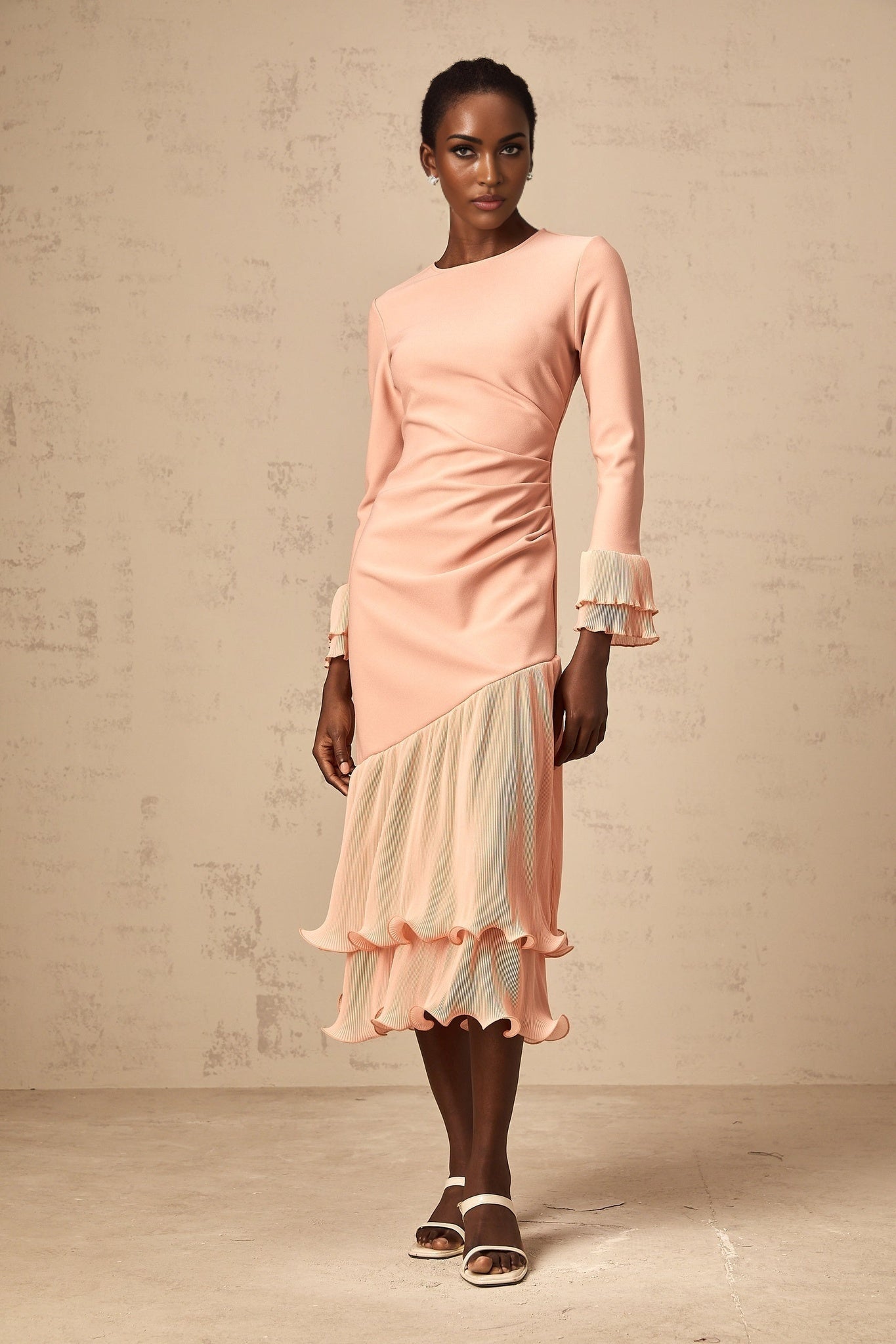A pink midi dress with ruffled trim and panel details featuring a feminine silhouette and flowy design
