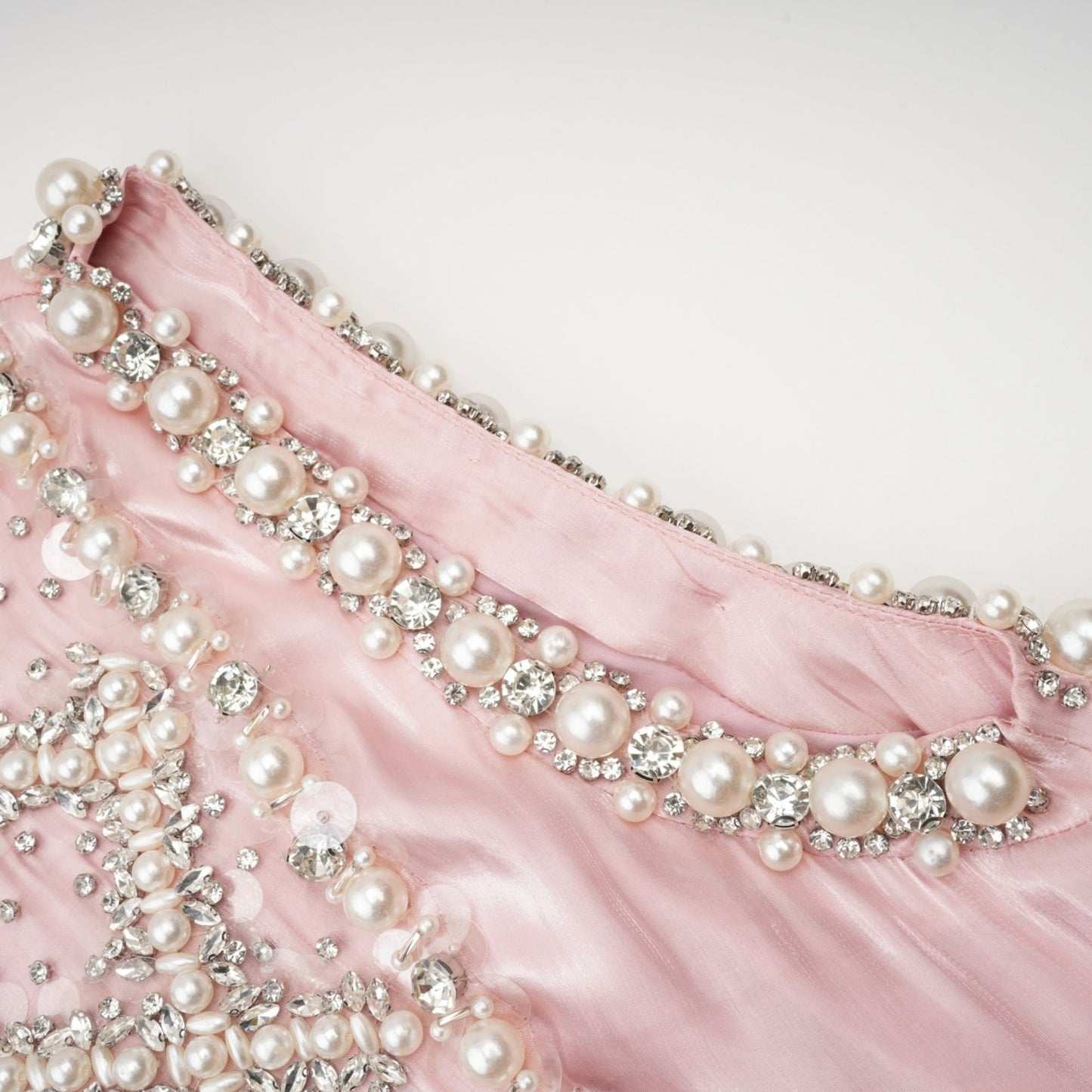 A pink mini dress with pleated skirt and embellished details named Helena