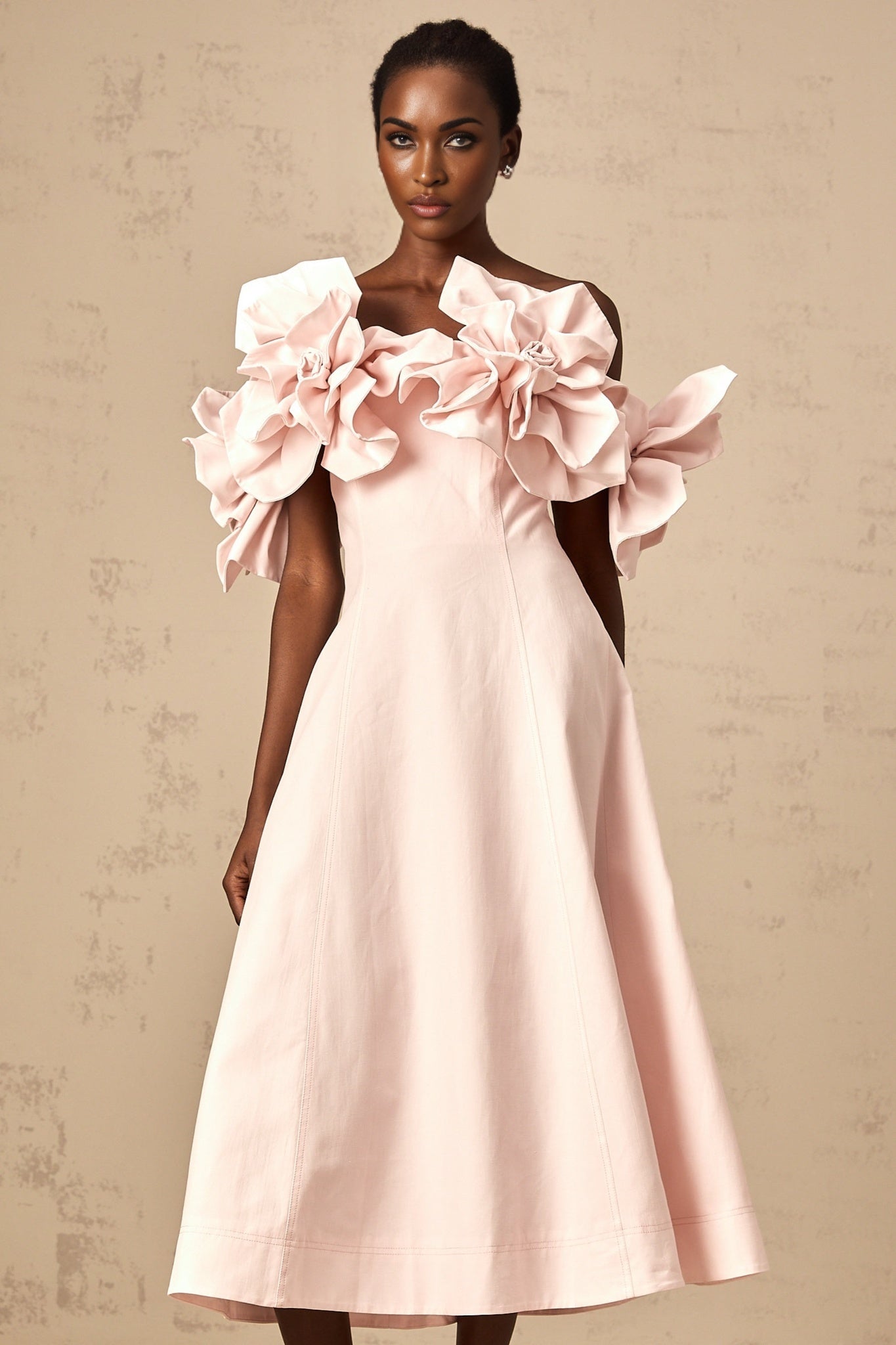 A pink offshoulder midi dress with 3D petal details named Juliette The dress features a fitted bodice and flared skirt with delicate floral embellishments
