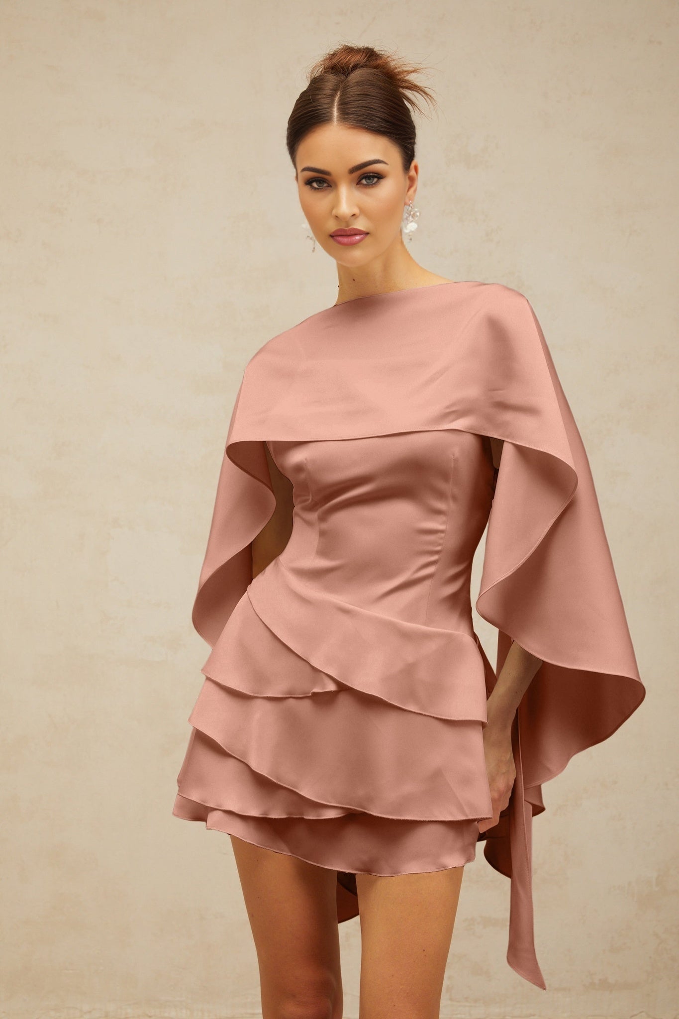 A pink satin mini dress with shawllike panel and ruffled details showcasing the Lyna design