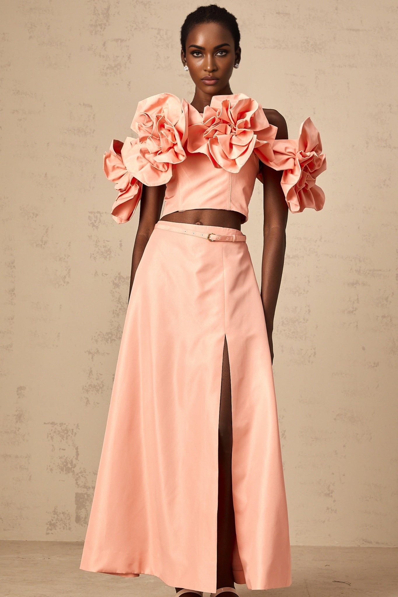 A pink twopiece outfit consisting of a top and skirt with floral applique details matching set by Yvette