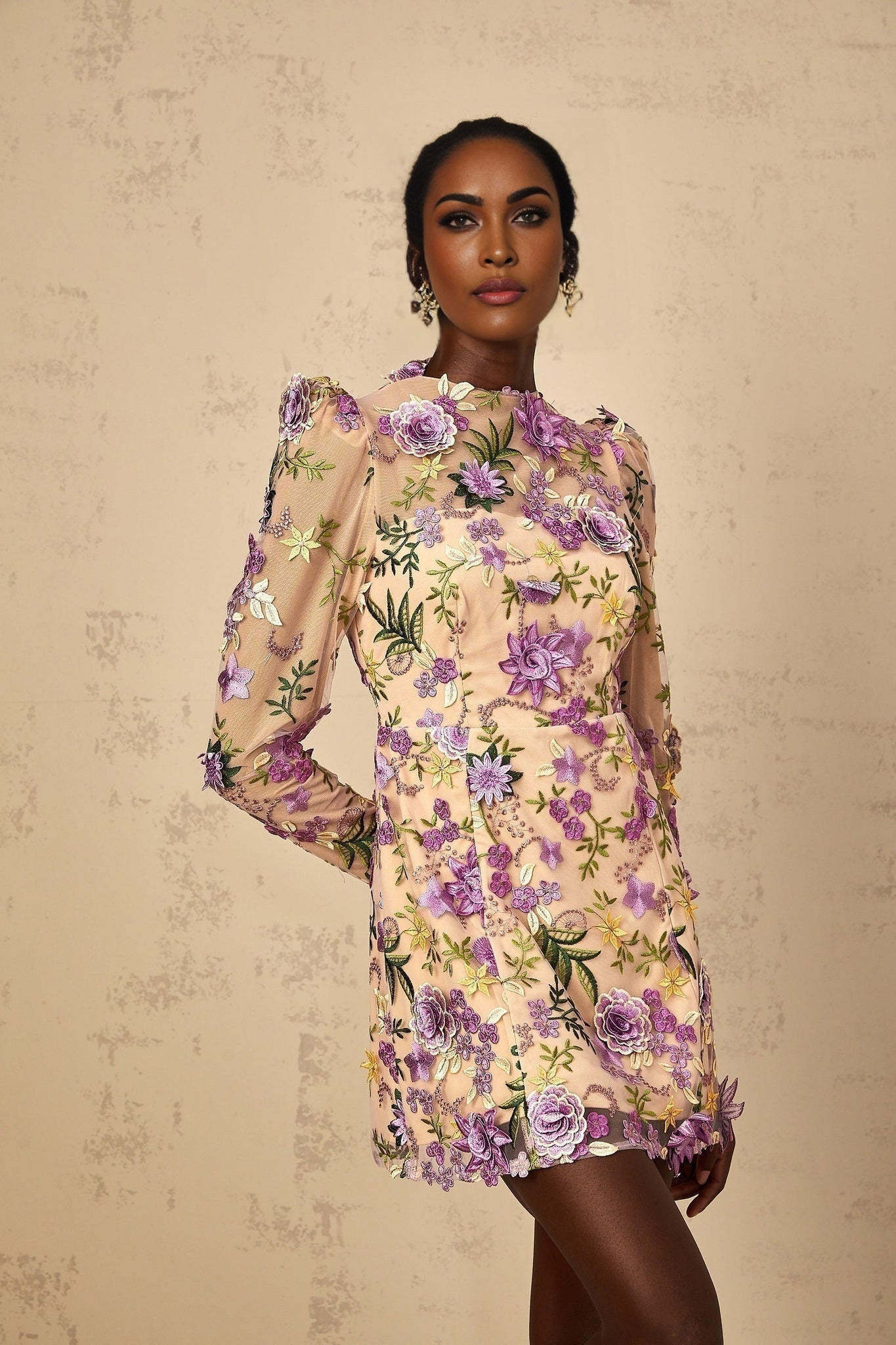A purple mini dress with floral applique and embroidered tulle featuring a fitted bodice and short flared skirt