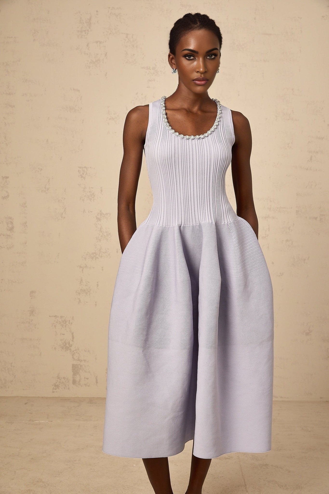 A purple ribbed knit midi dress with embellishments and a form fitting silhouette