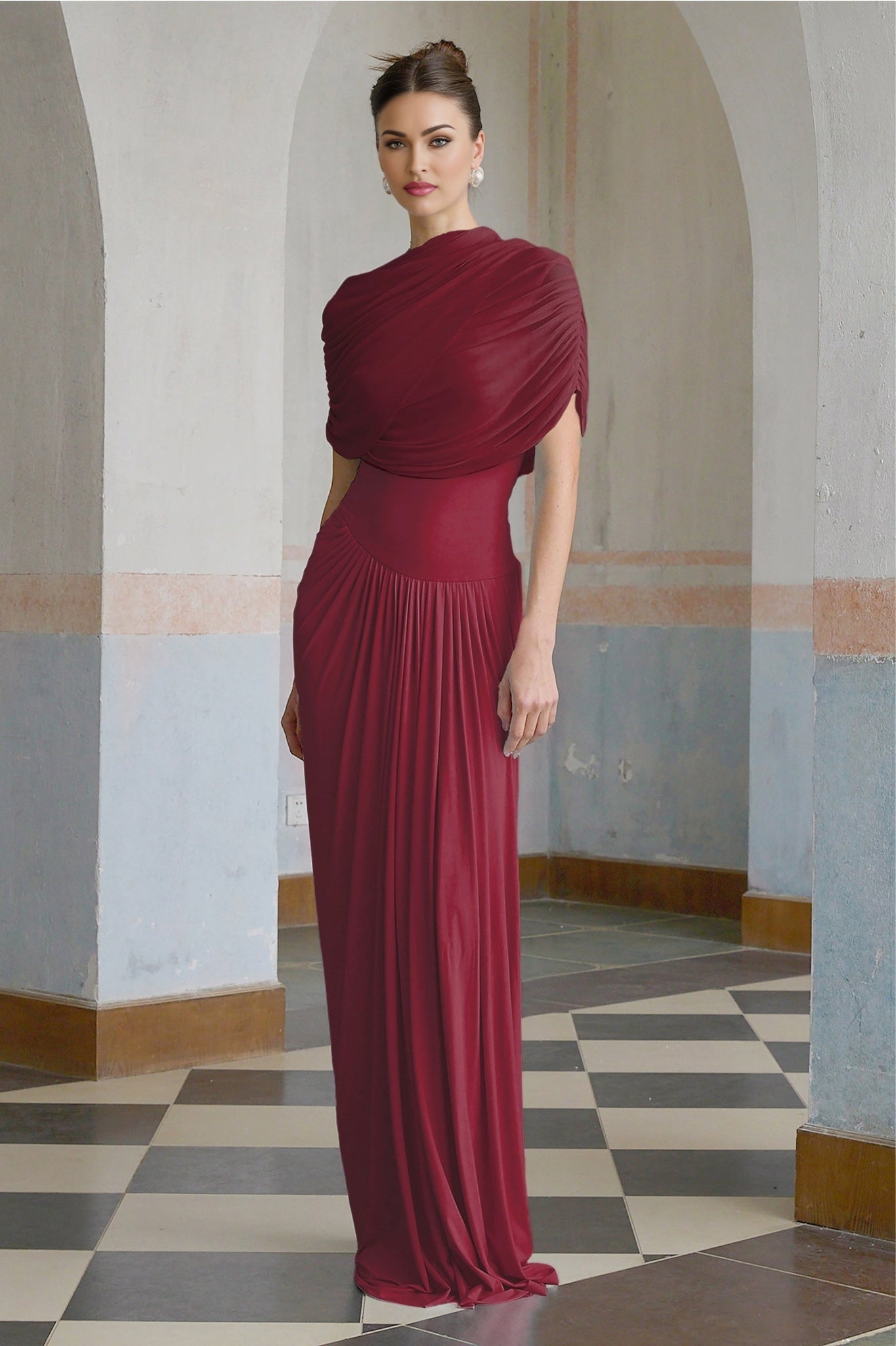 A red asymmetric maxi dress with pleated details and a long flowing skirt worn by a model