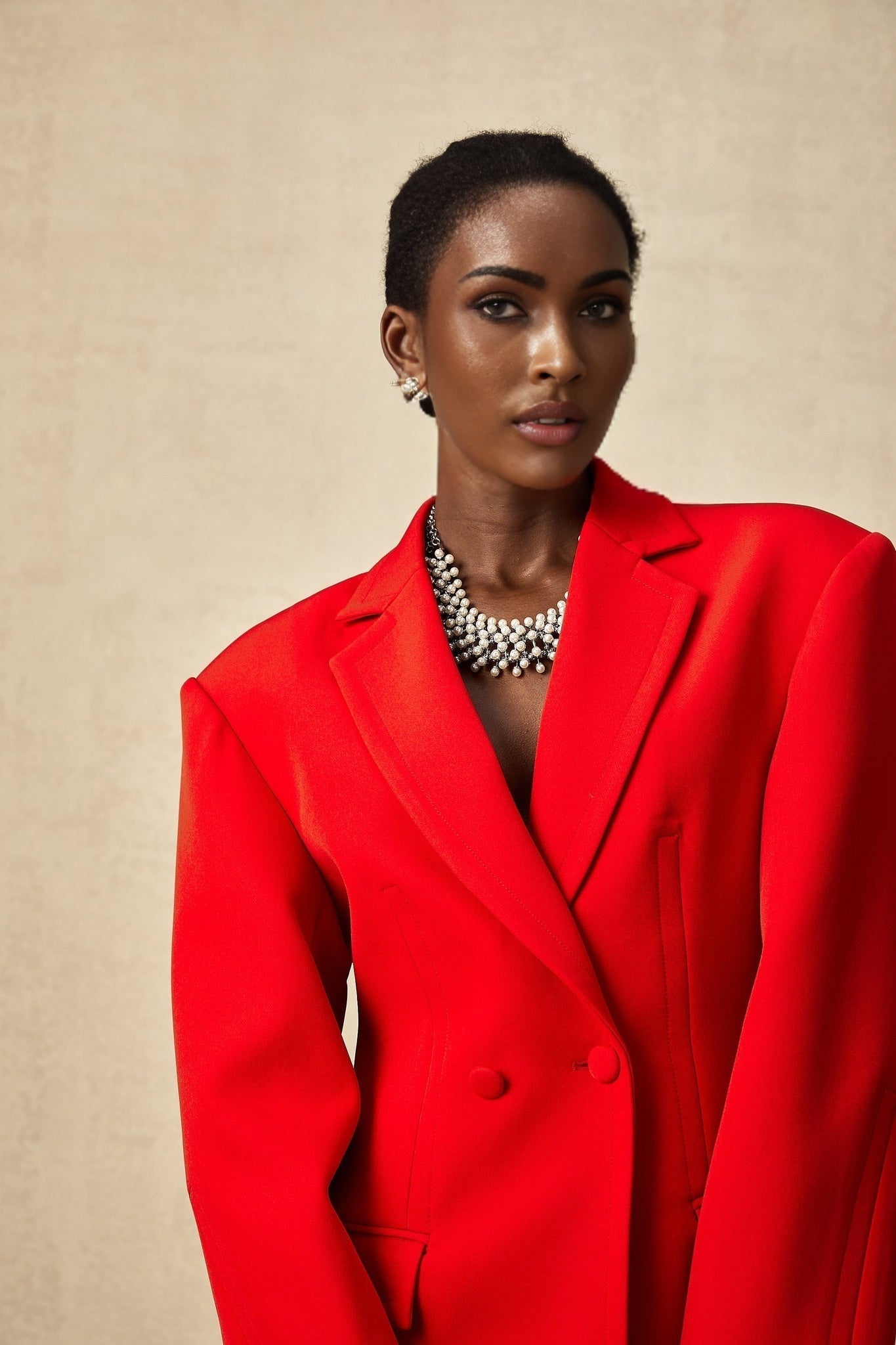 A red blazer with hourglass silhouette and doublebreasted front closure