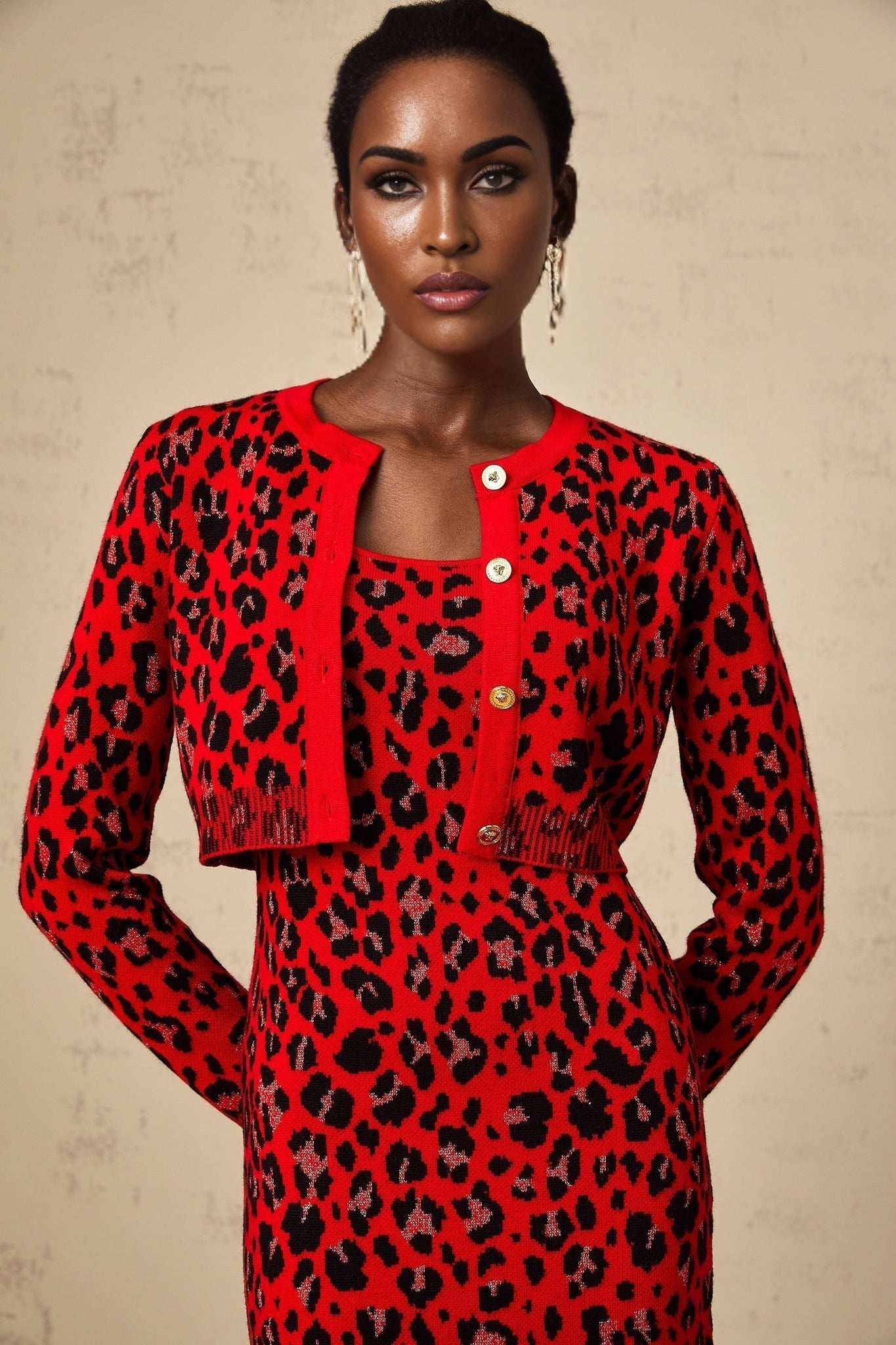 A red cardigan with a leopard print pattern made from shimmery lurex fabric