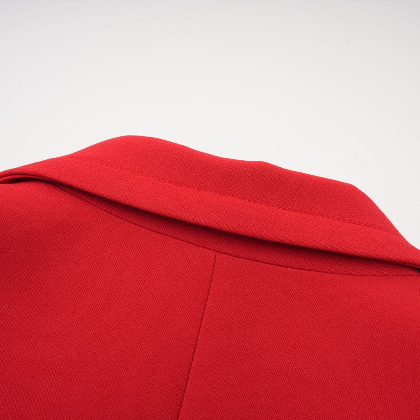 A red doublebreasted blazer with an hourglass silhouette featuring a fitted waist and structured shoulders