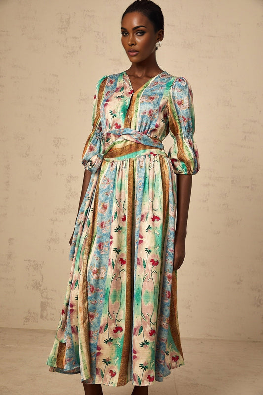 A red floral print wrap dress with a midi length skirt featuring a vibrant cherry blossom pattern on a dark background