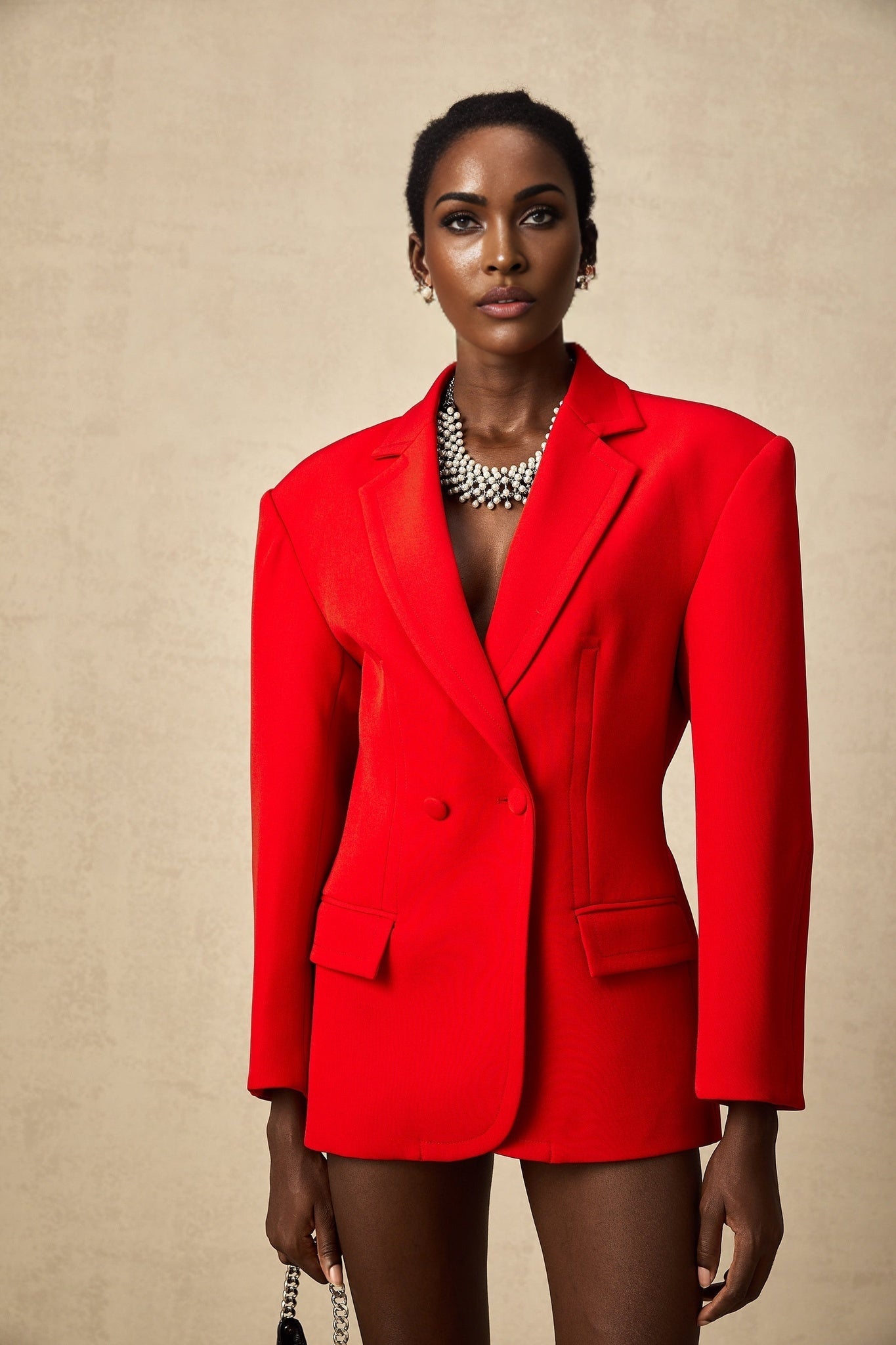 A red hourglass shaped double breasted blazer with a fitted waist and flared hem creating an hourglass silhouette